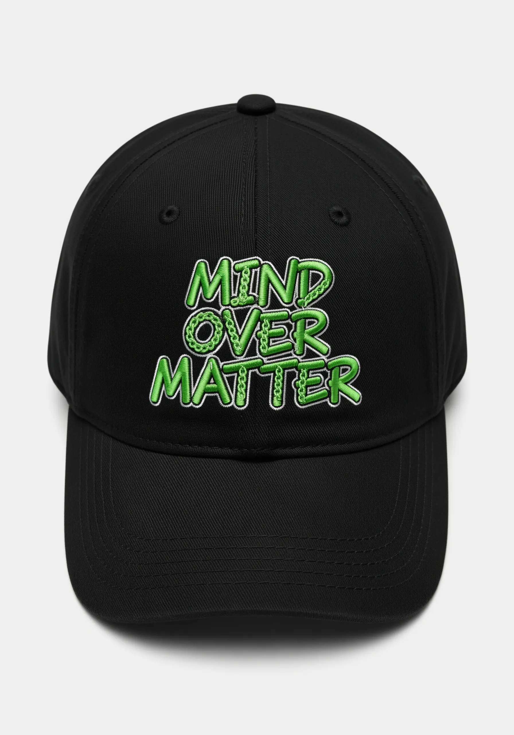 “MIND OVER MATTER” in green textured embroidery with a white outline on a black cap.