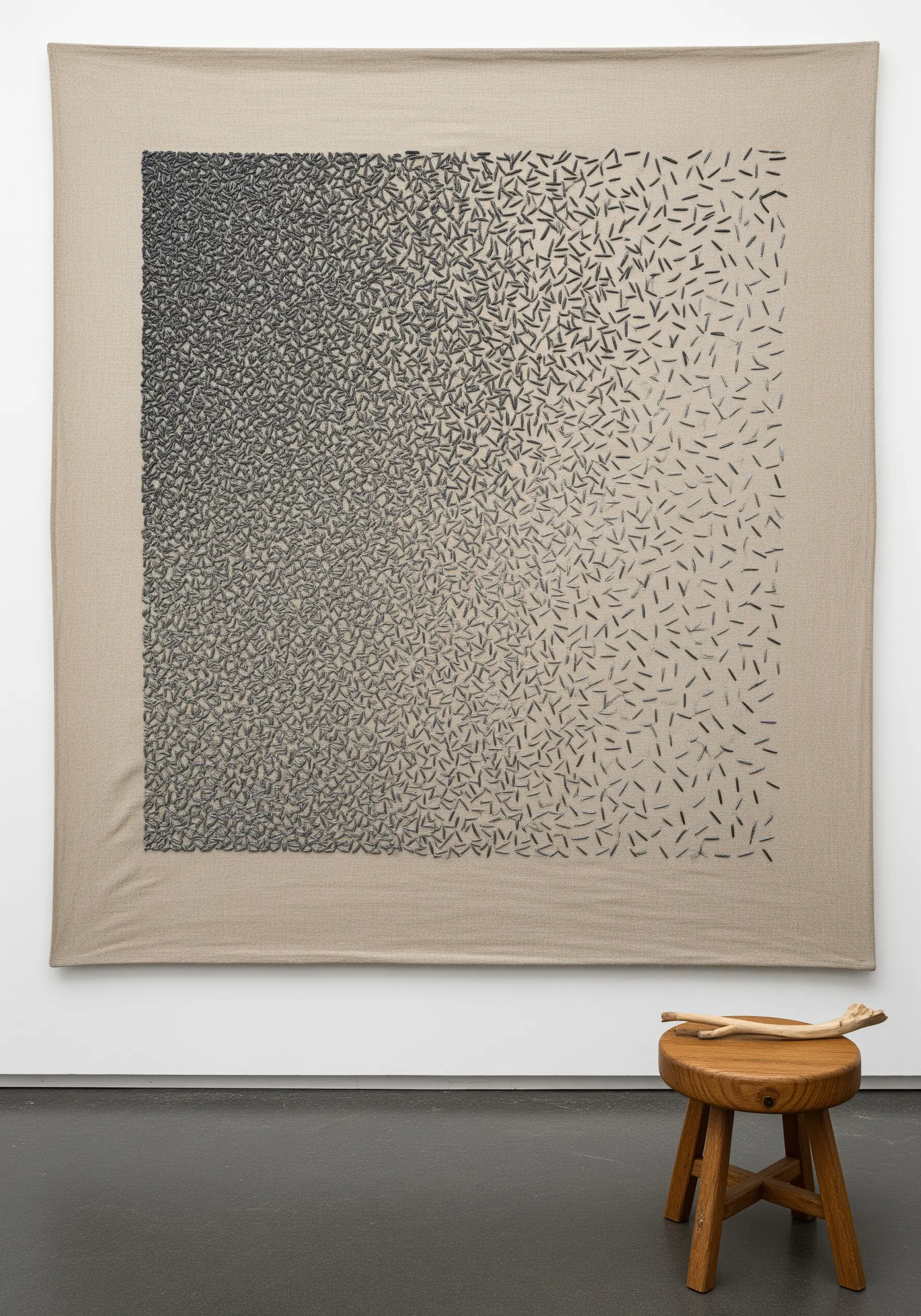 A large textile wall hanging with a gradient effect created by varying the density of small black stitches.