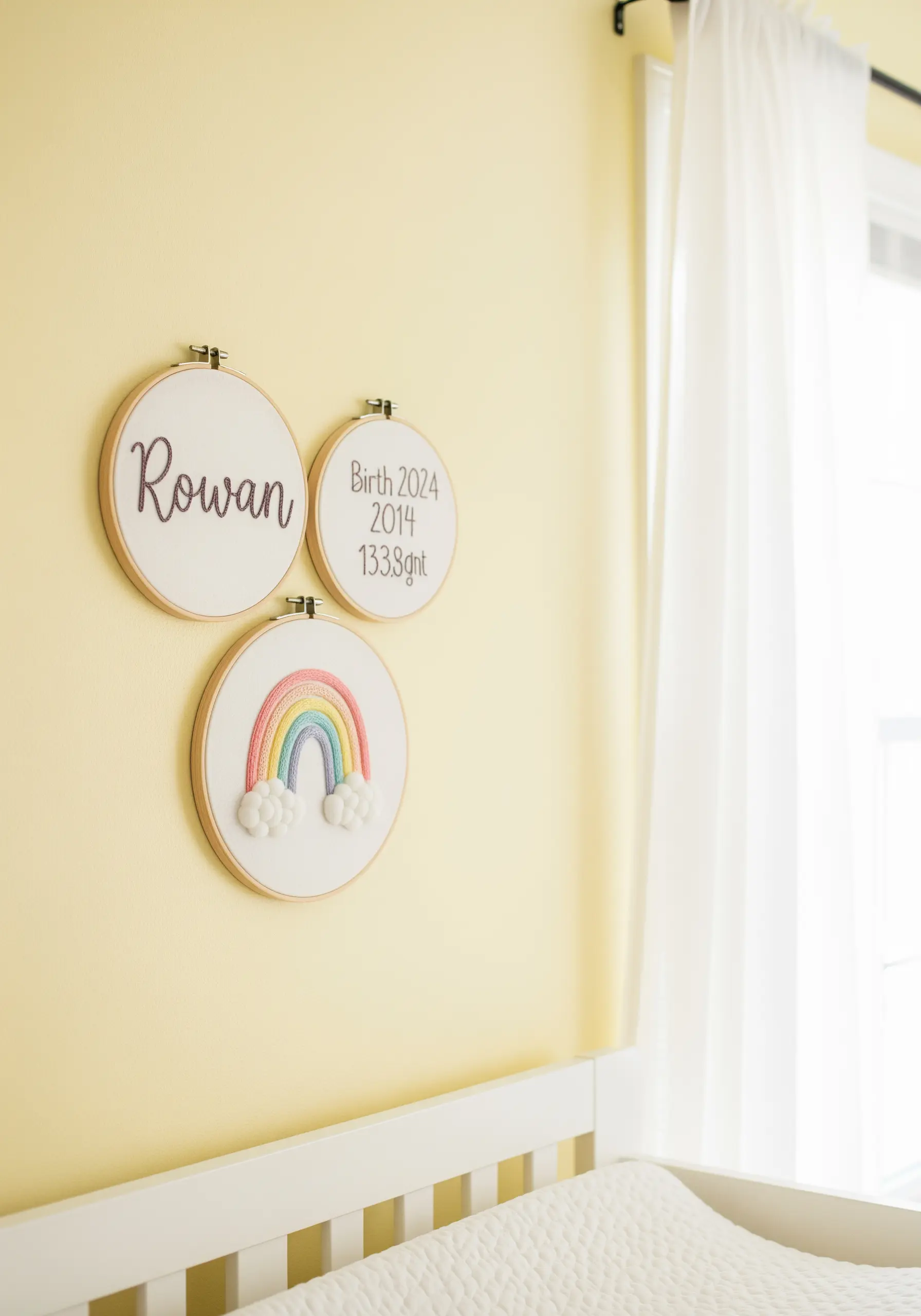 A gallery of three embroidery hoops for a nursery with a name, birth stats, and a textured rainbow.