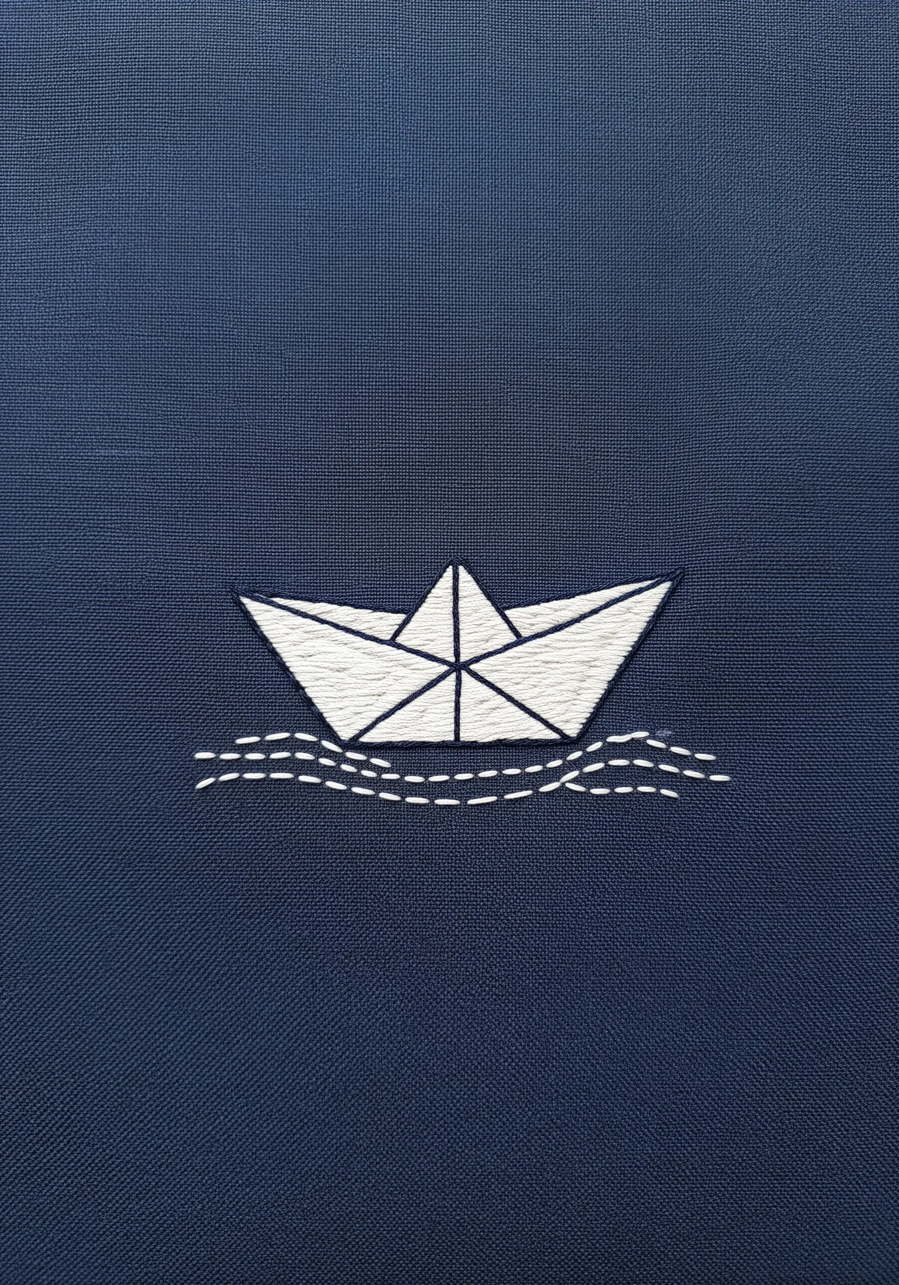 A white origami paper boat embroidered on dark blue fabric with geometric satin stitch.