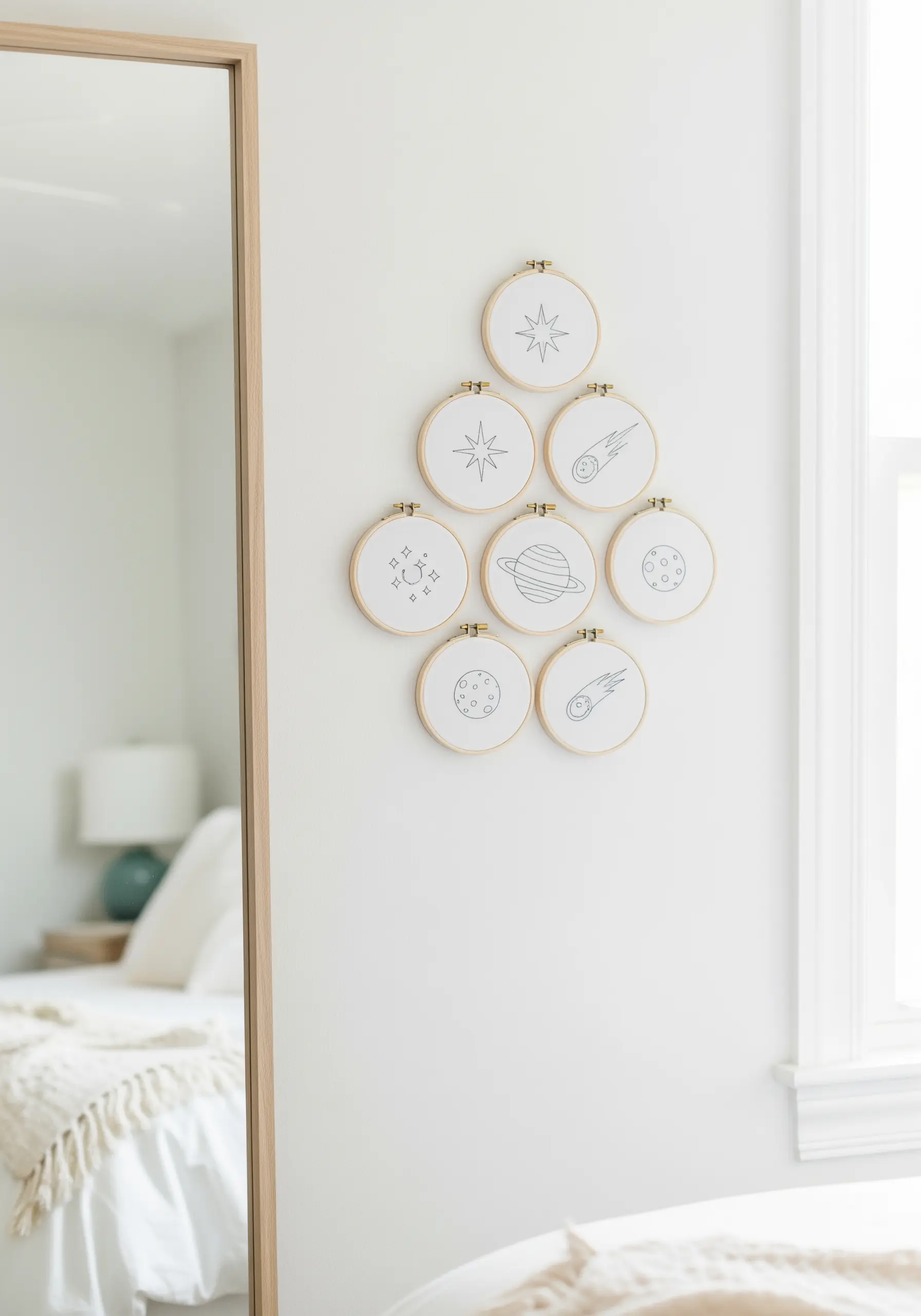 A cluster of small embroidery hoops featuring simple line art of planets, stars, and comets.