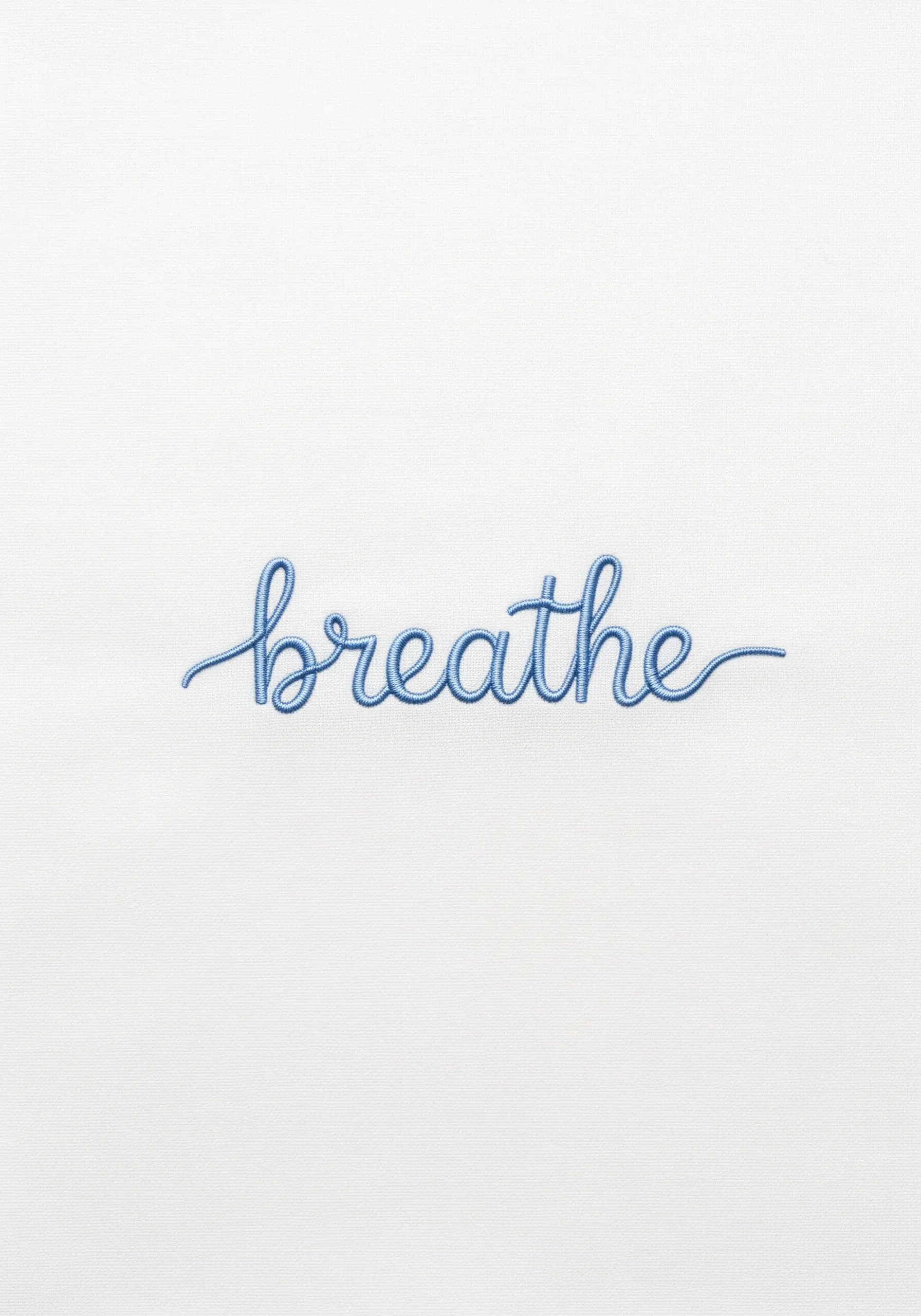Blue cursive text embroidery saying breathe on white fabric