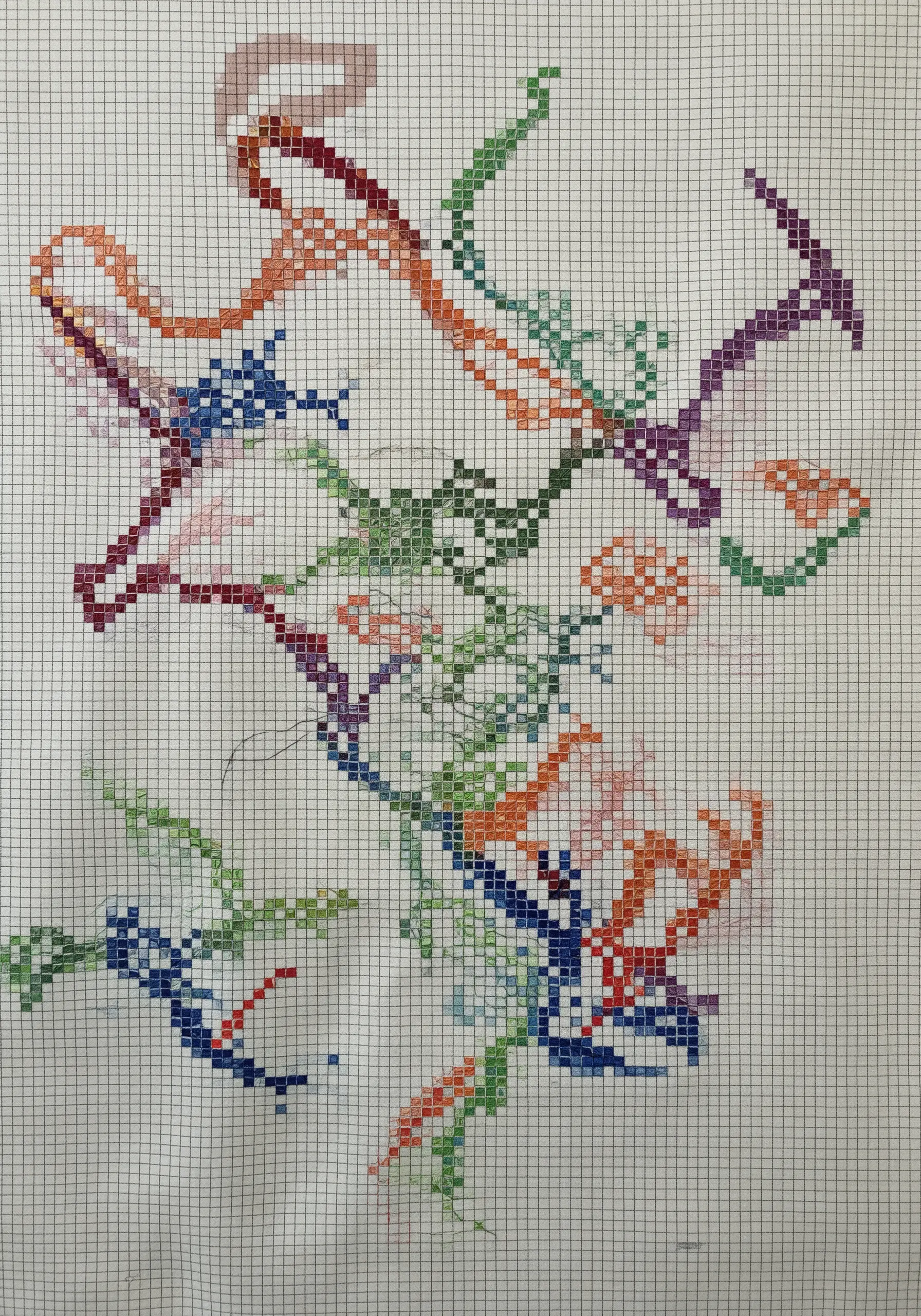 Abstract, colorful cross-stitch patterns stitched directly onto graph paper.
