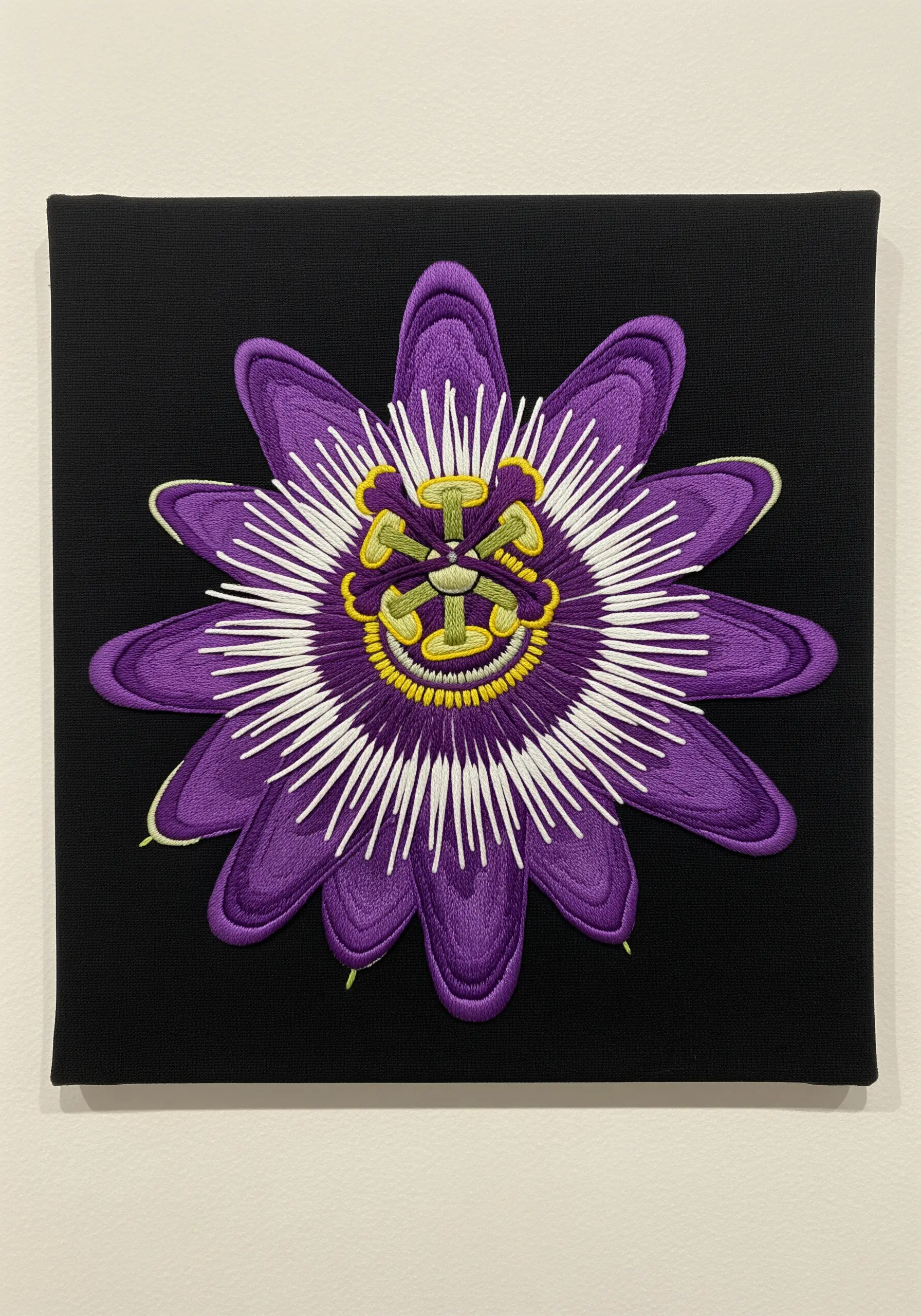 A complex and graphic embroidery of a passionflower on a black canvas.
