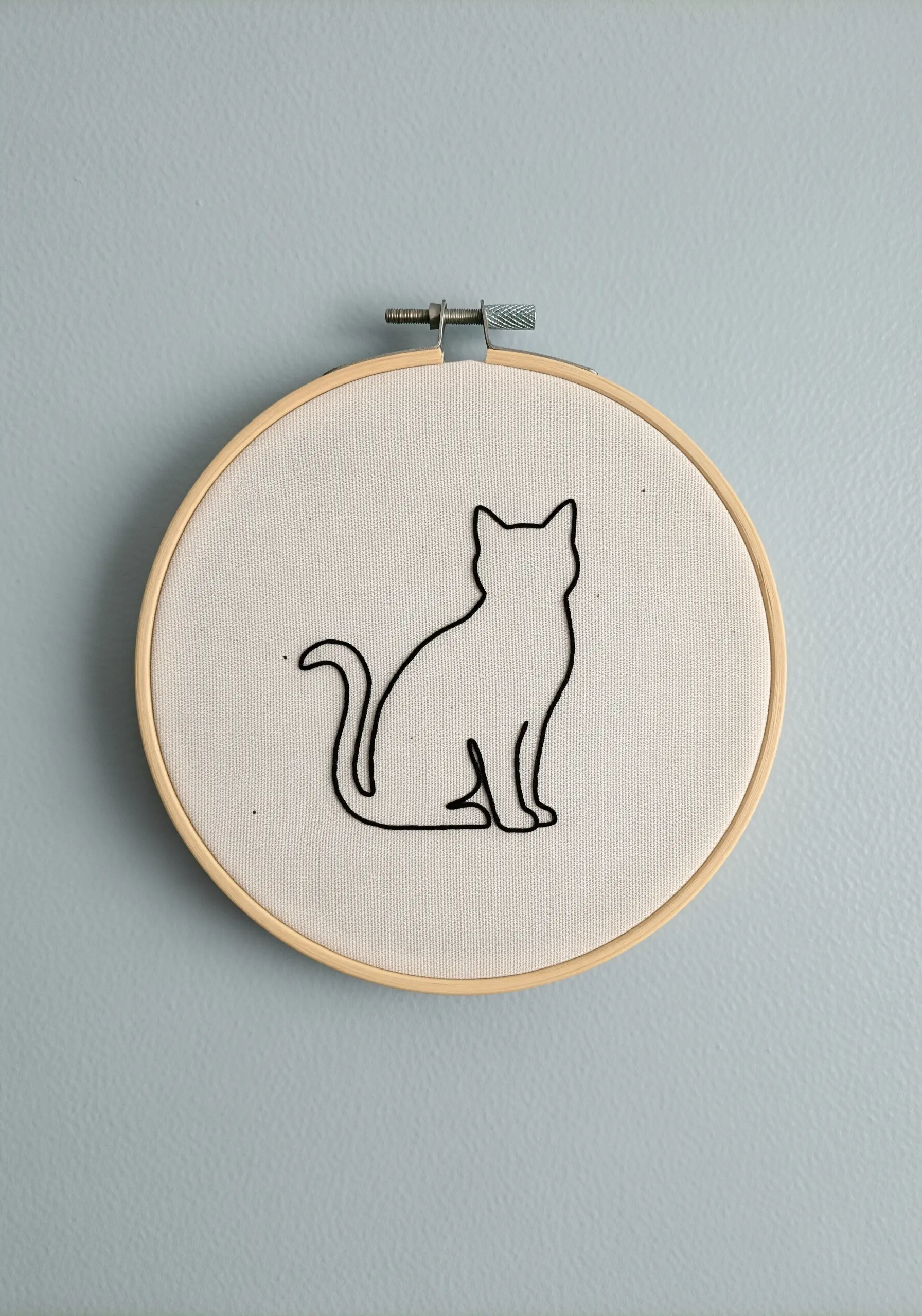 A clean, simple black outline of a sitting cat on a neutral background.