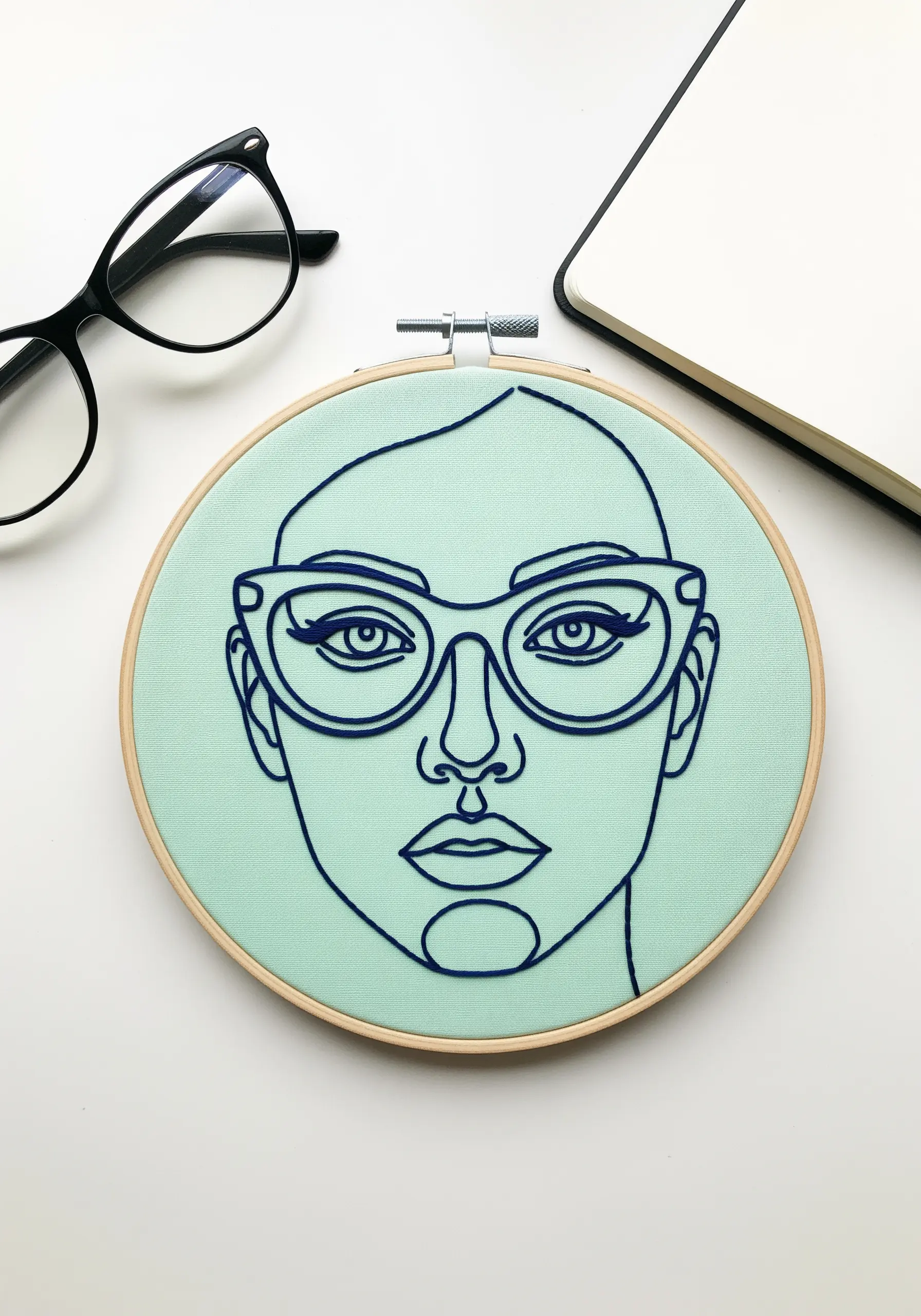 Line-art portrait with bold, navy blue cat-eye glasses on a mint background.