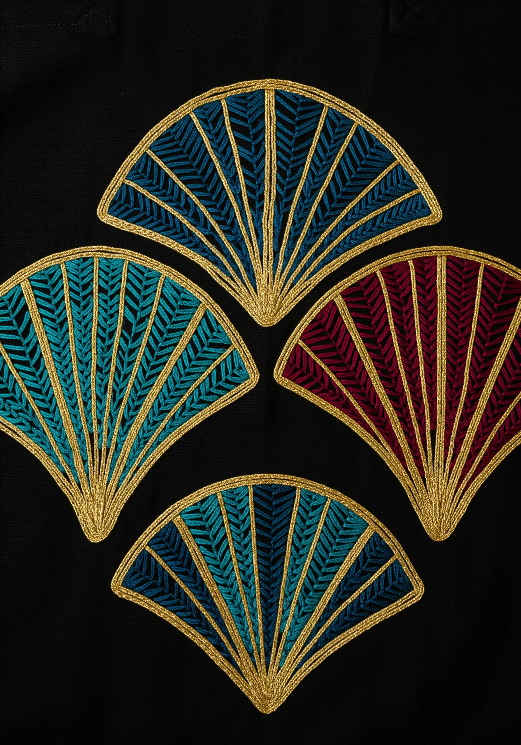 Four Art Deco style fans with bold gold couched outlines on a black tote bag.