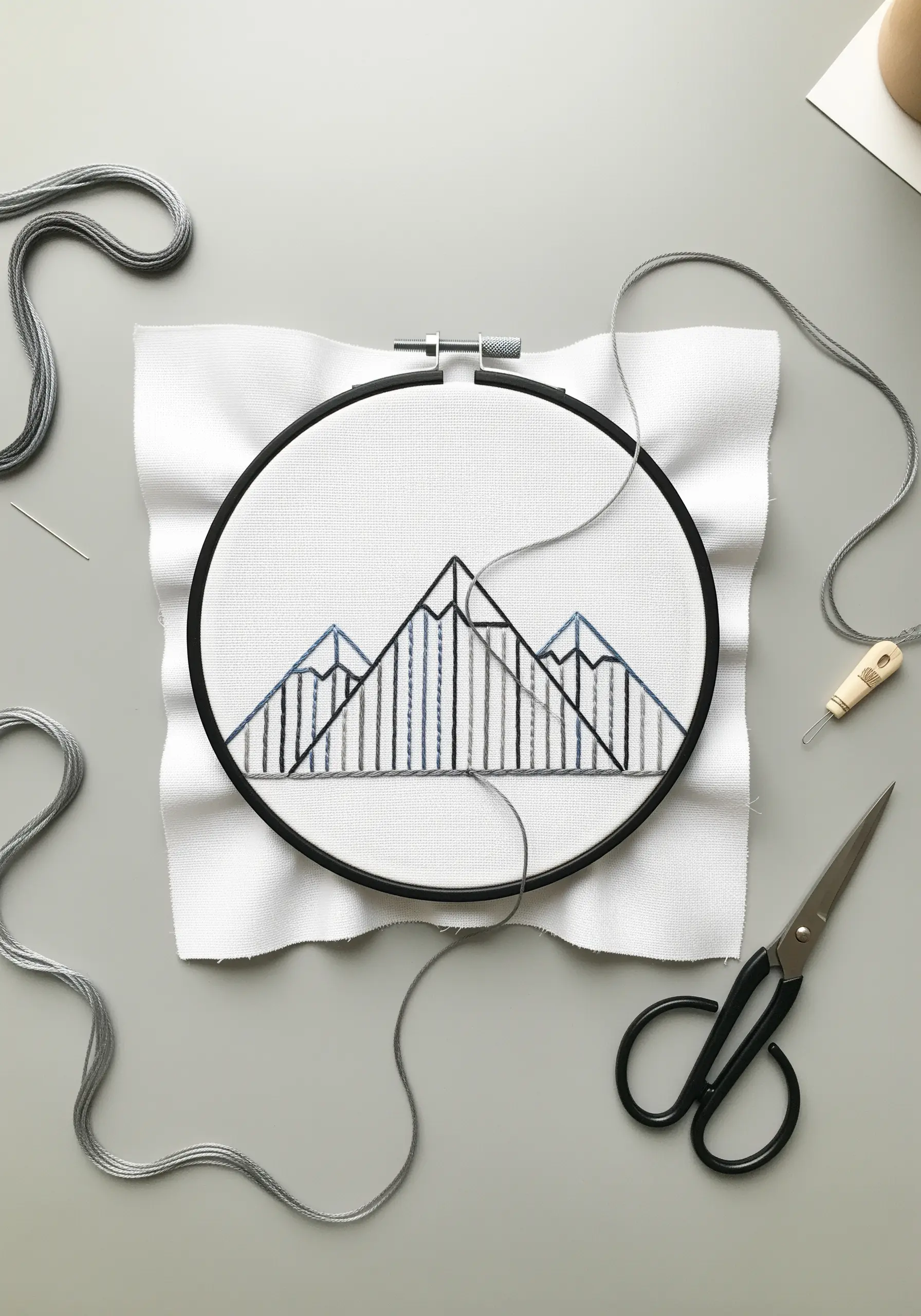 Minimalist geometric mountains created with straight stitches and negative space