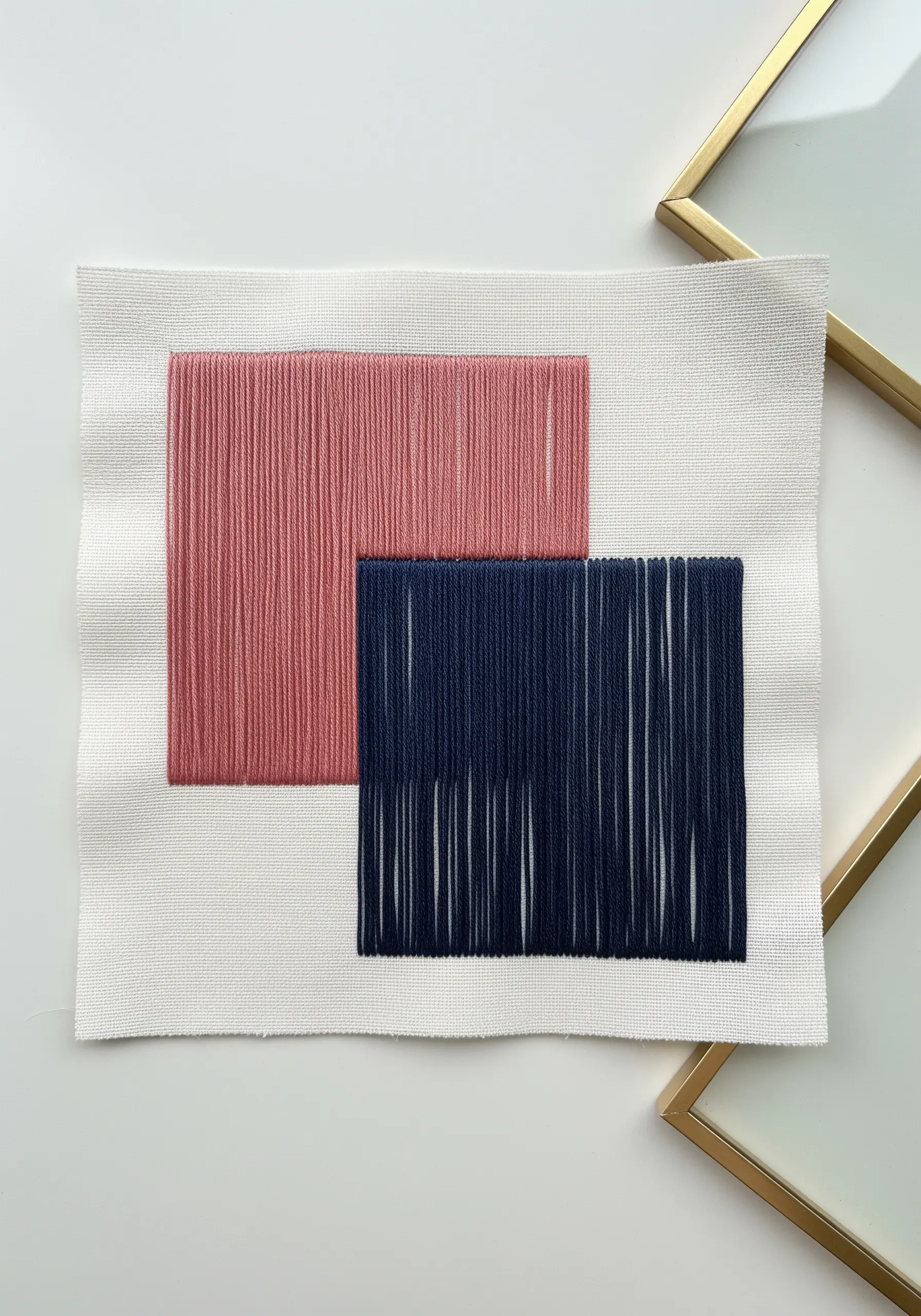 Two overlapping abstract rectangles in pink and navy blue satin stitch.