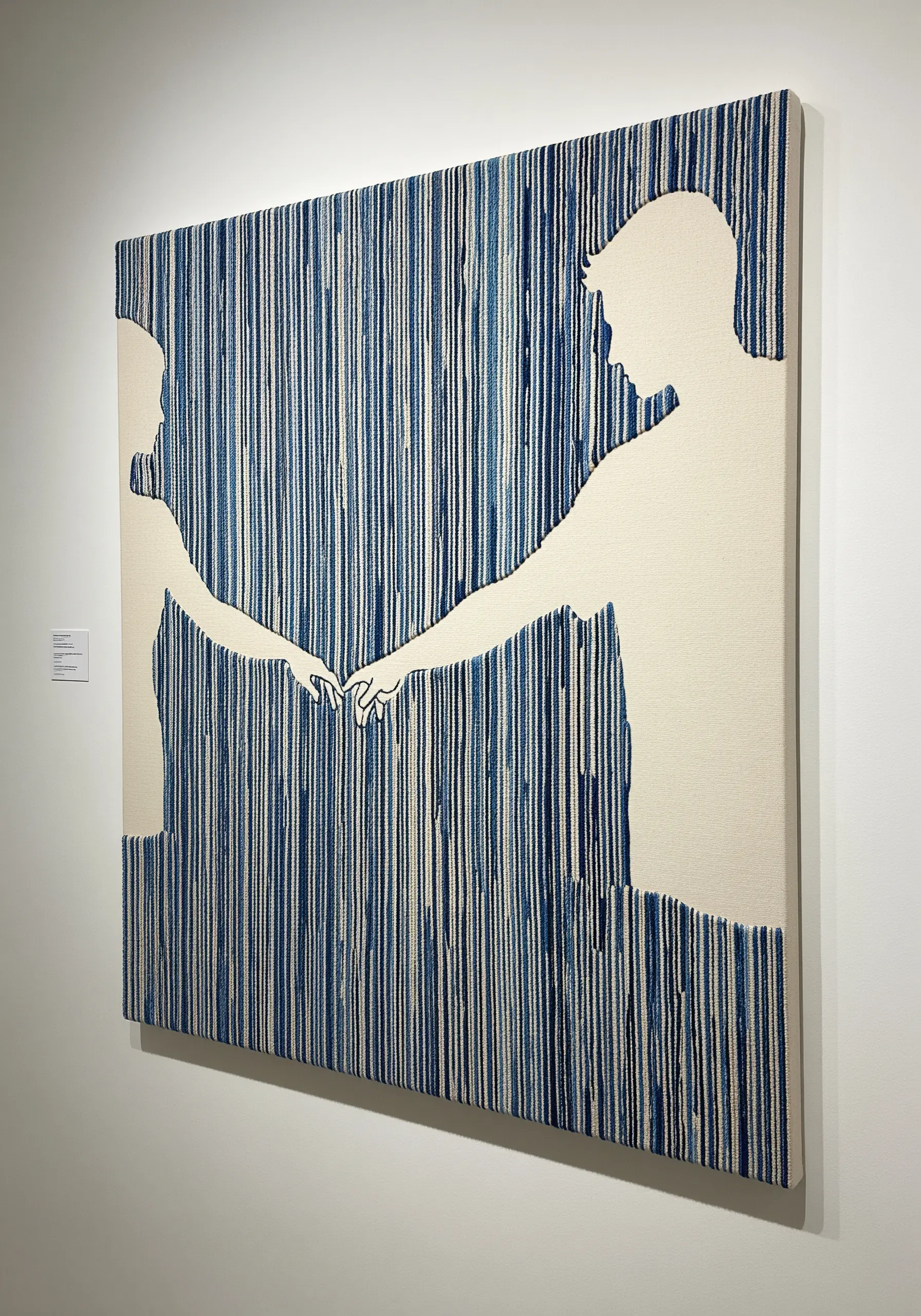 A couple's silhouette created from the negative space of a vertically stitched blue background.