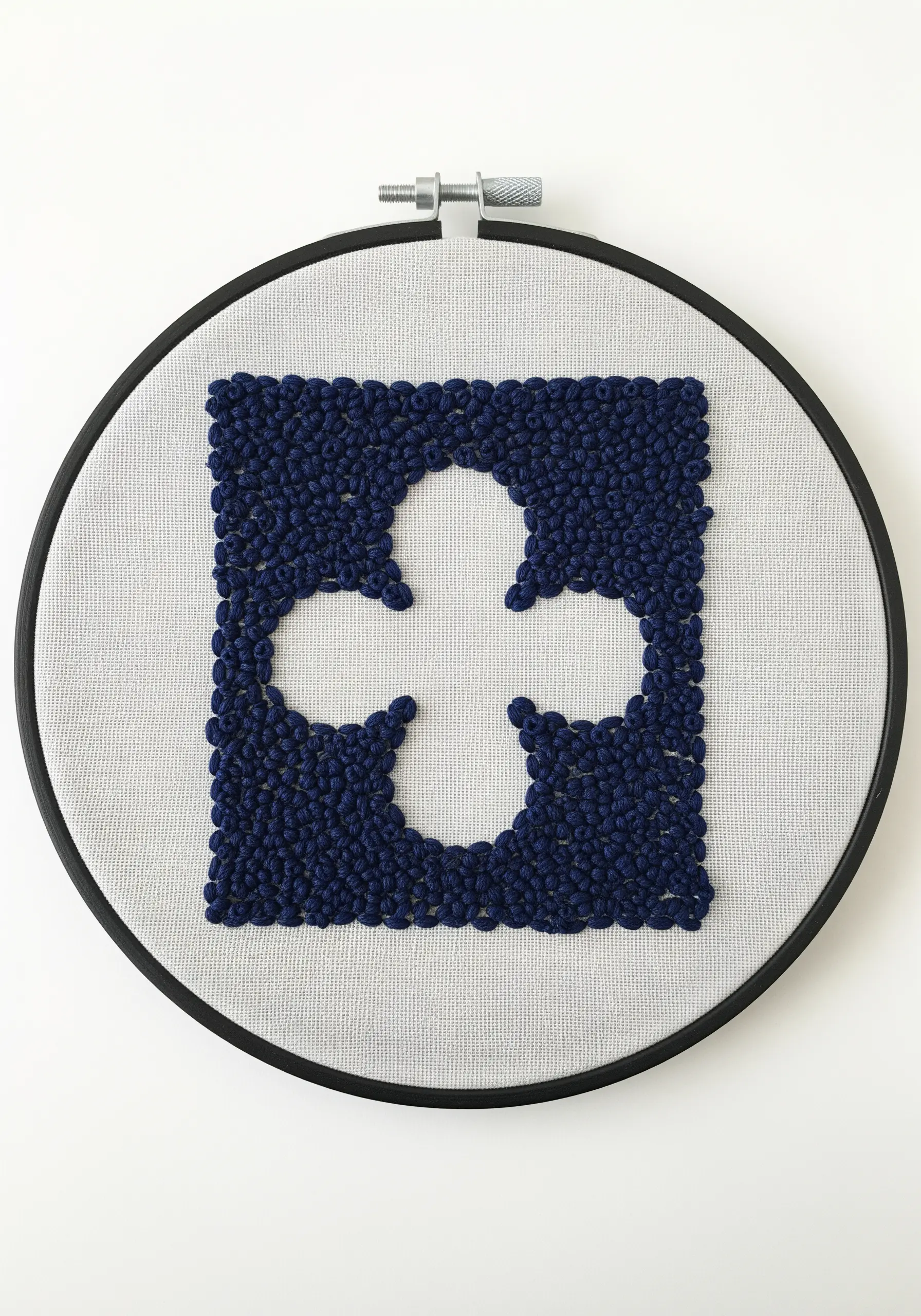 A four-leaf clover shape created by filling the negative space with navy blue French knots.