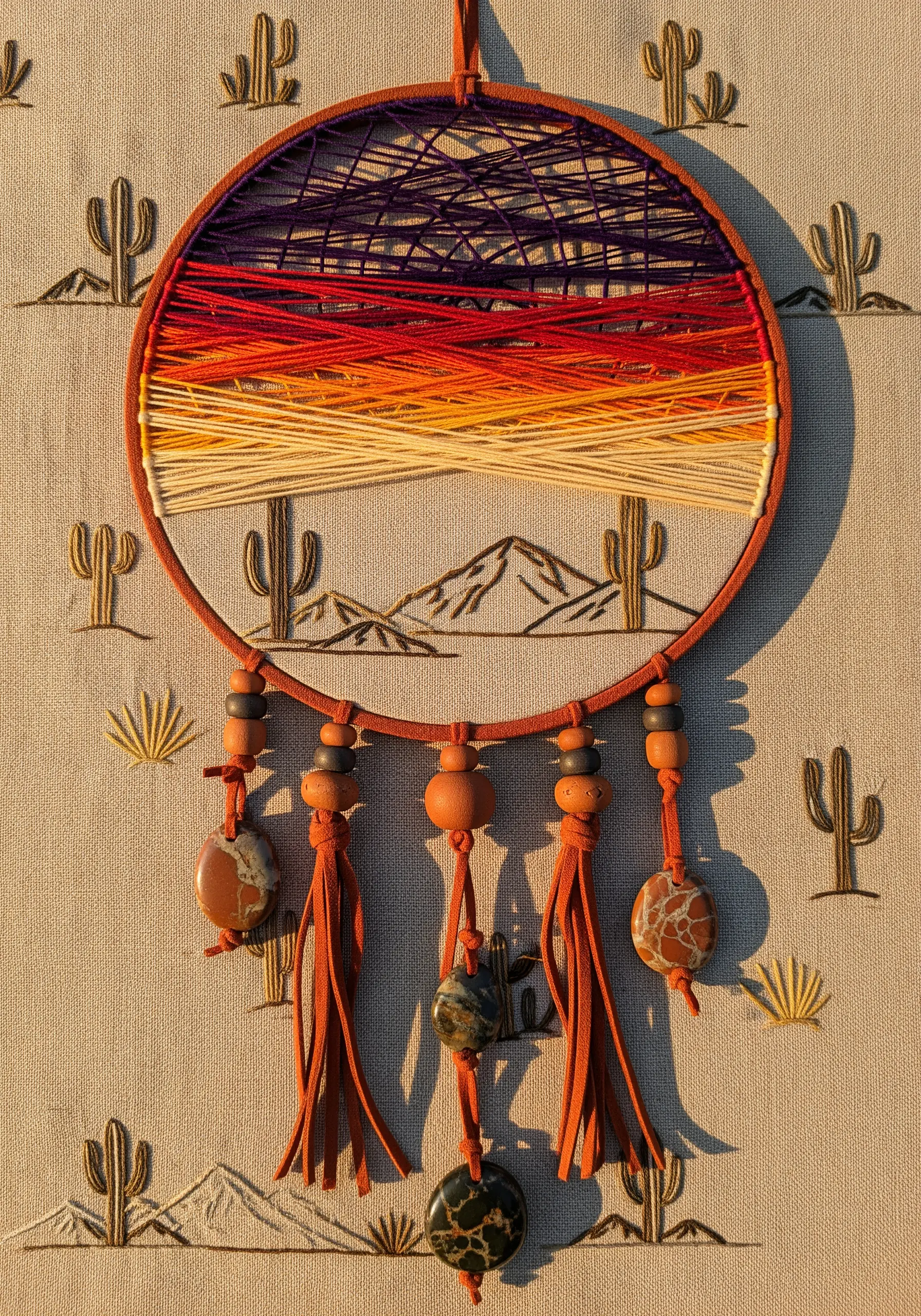 String art dreamcatcher with a desert sunset color gradient and cactus embroidery.