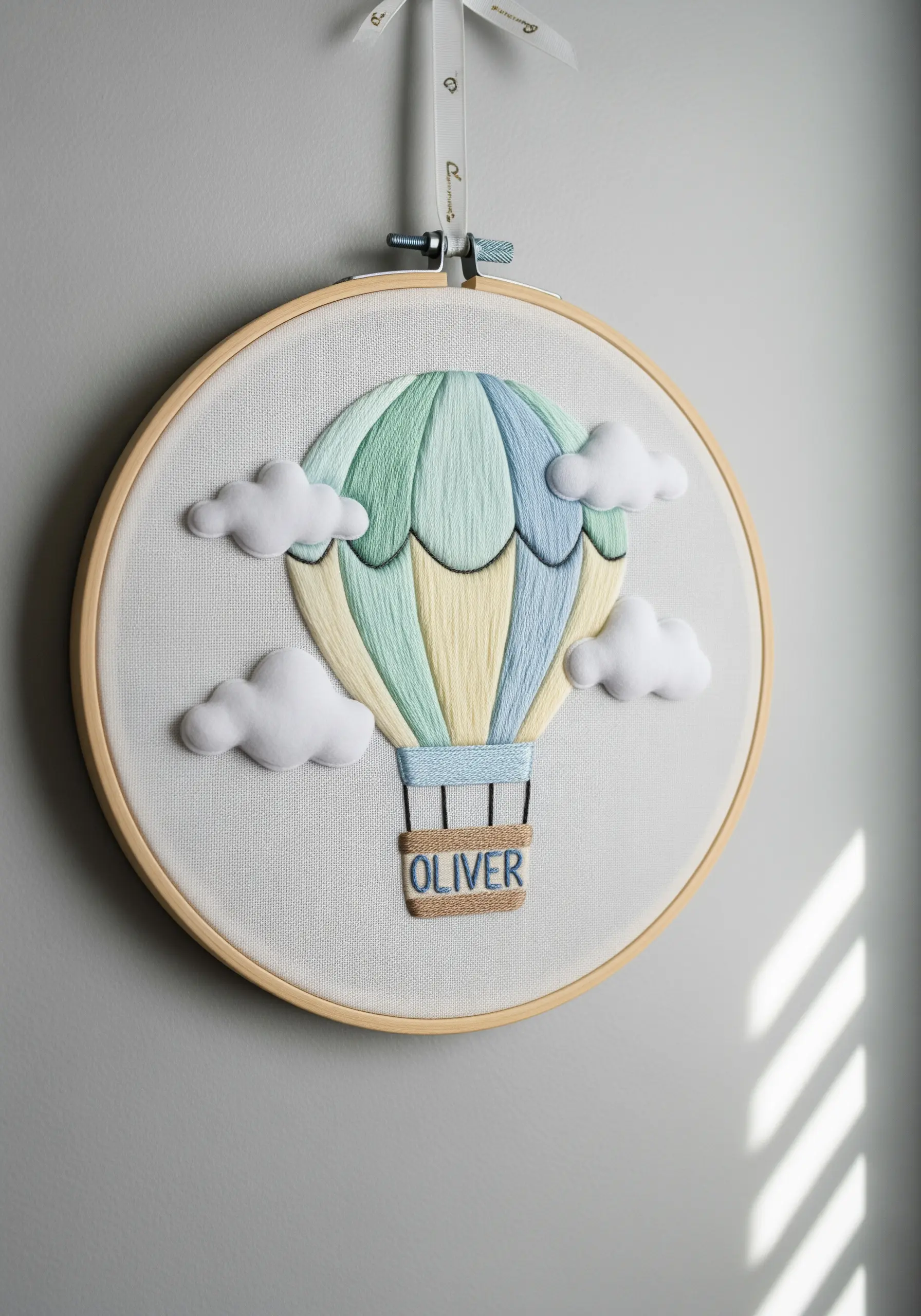 A nursery embroidery hoop with a 3D hot air balloon and fluffy felt clouds.