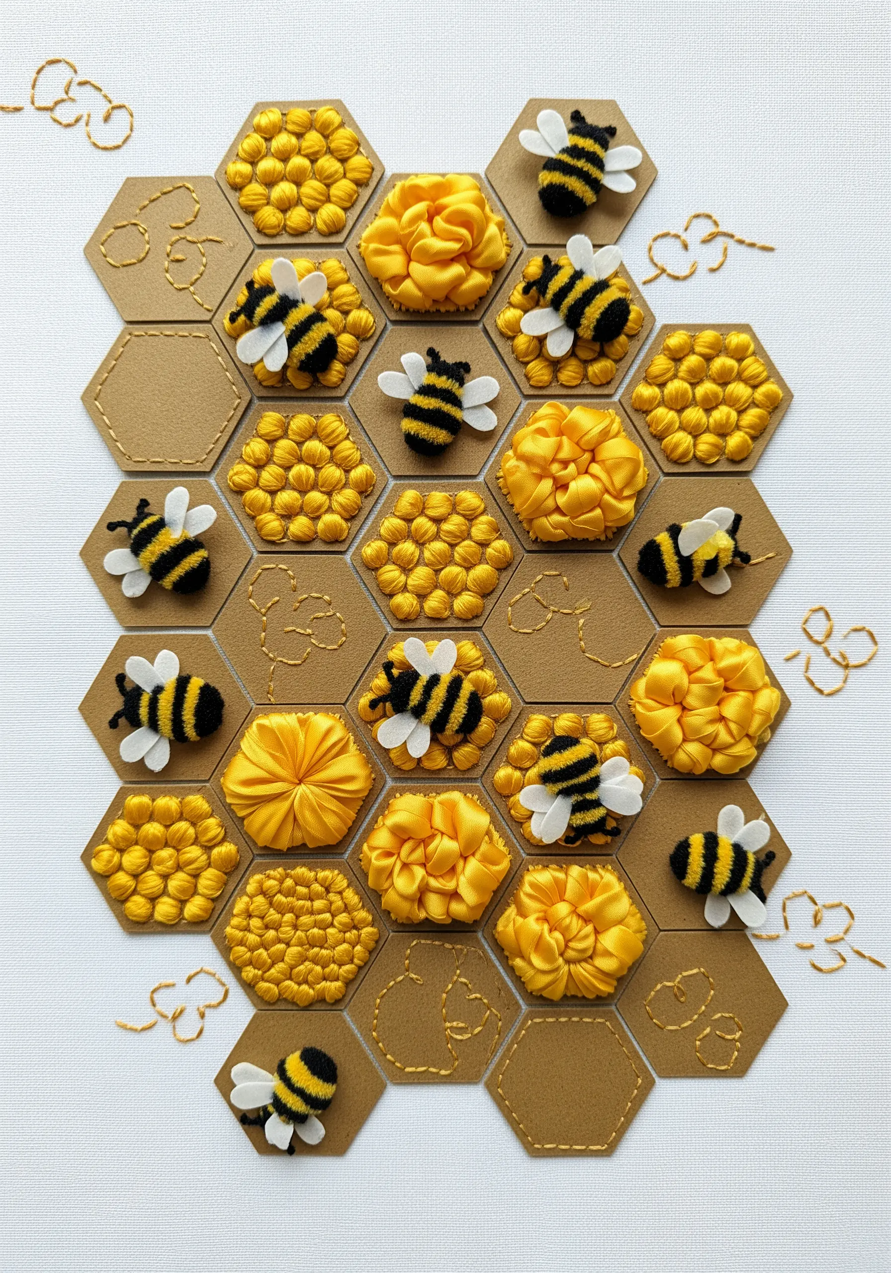 A honeycomb design filled with ribbon embroidery, textured stitches, and small felt bees.