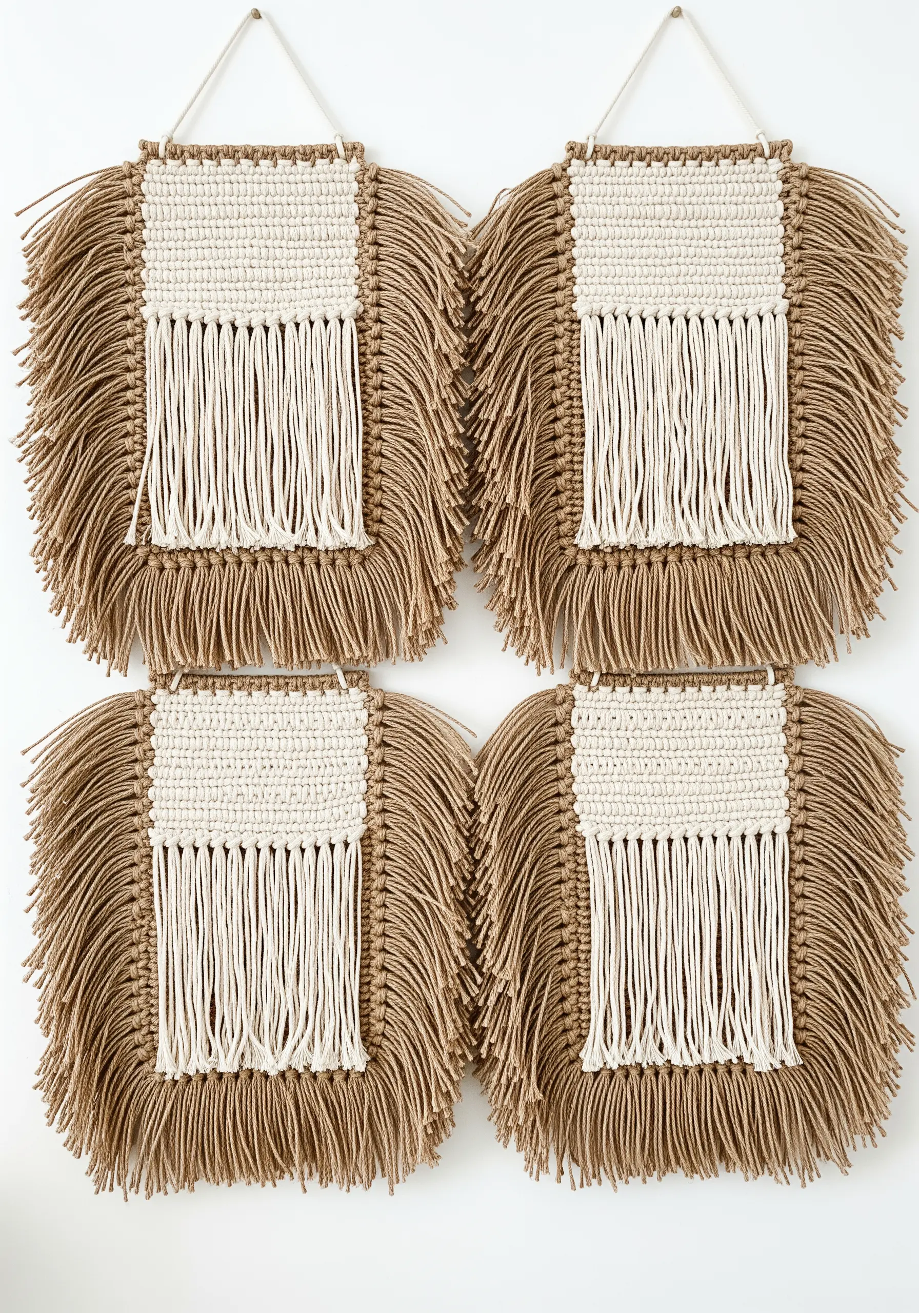 Four square macrame panels with jute and cotton fringe, arranged in a grid.