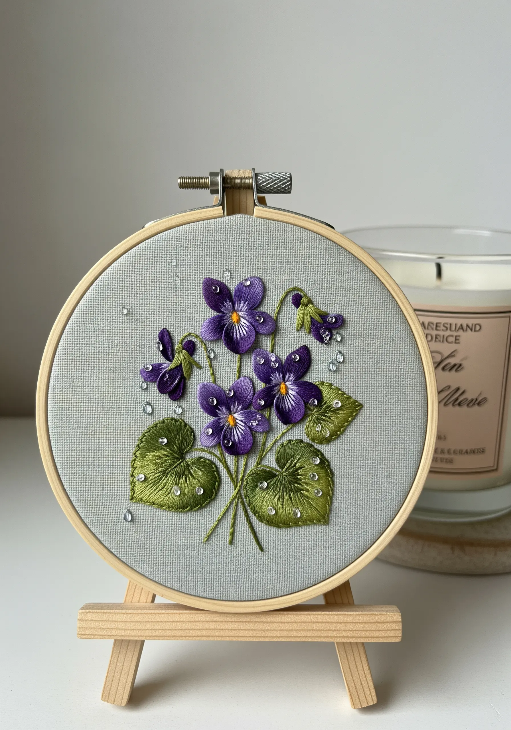 Embroidered purple violets and green leaves with clear seed beads as water droplets.