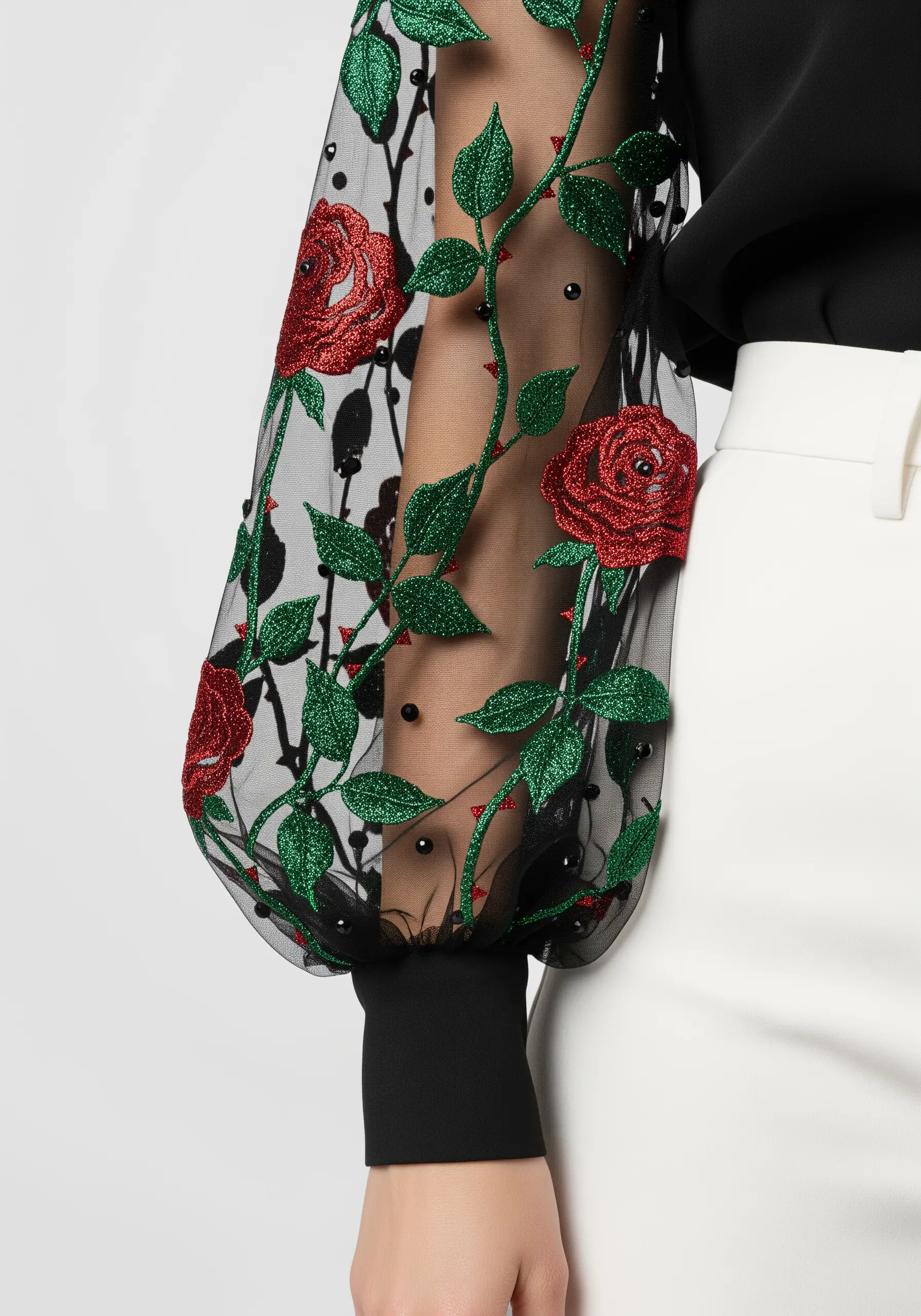 Red glitter roses and green glitter vines with beads embroidered on a sheer black sleeve.
