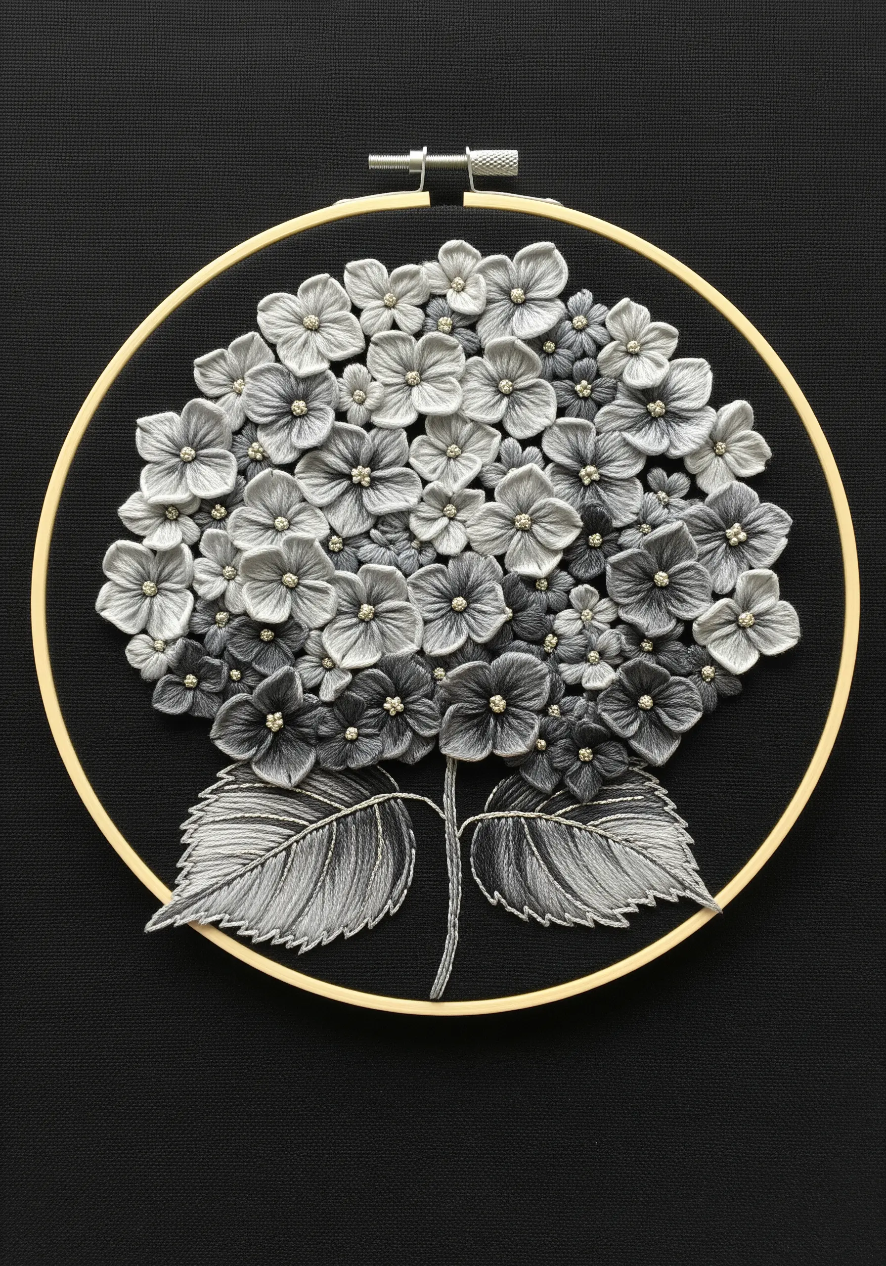A monochrome hydrangea embroidered in shades of grey with thread-painted petals on black fabric.