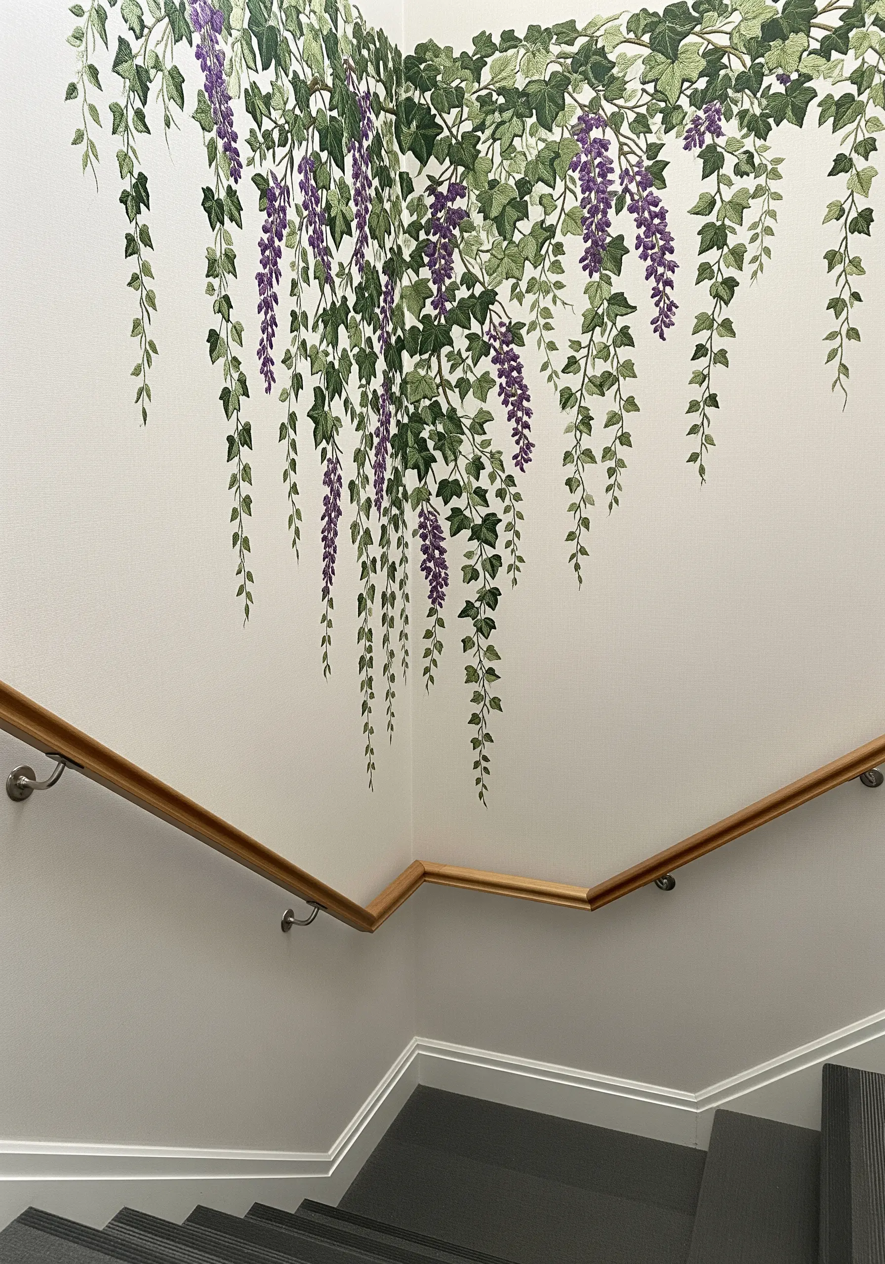 Embroidered wisteria vines cascading down from the ceiling in the corner of a staircase.