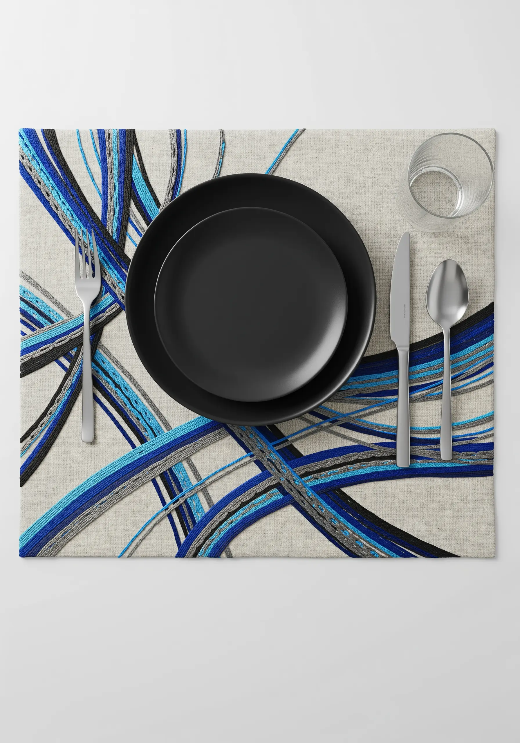 Abstract placemat embroidery with overlapping blue, black, and grey threads