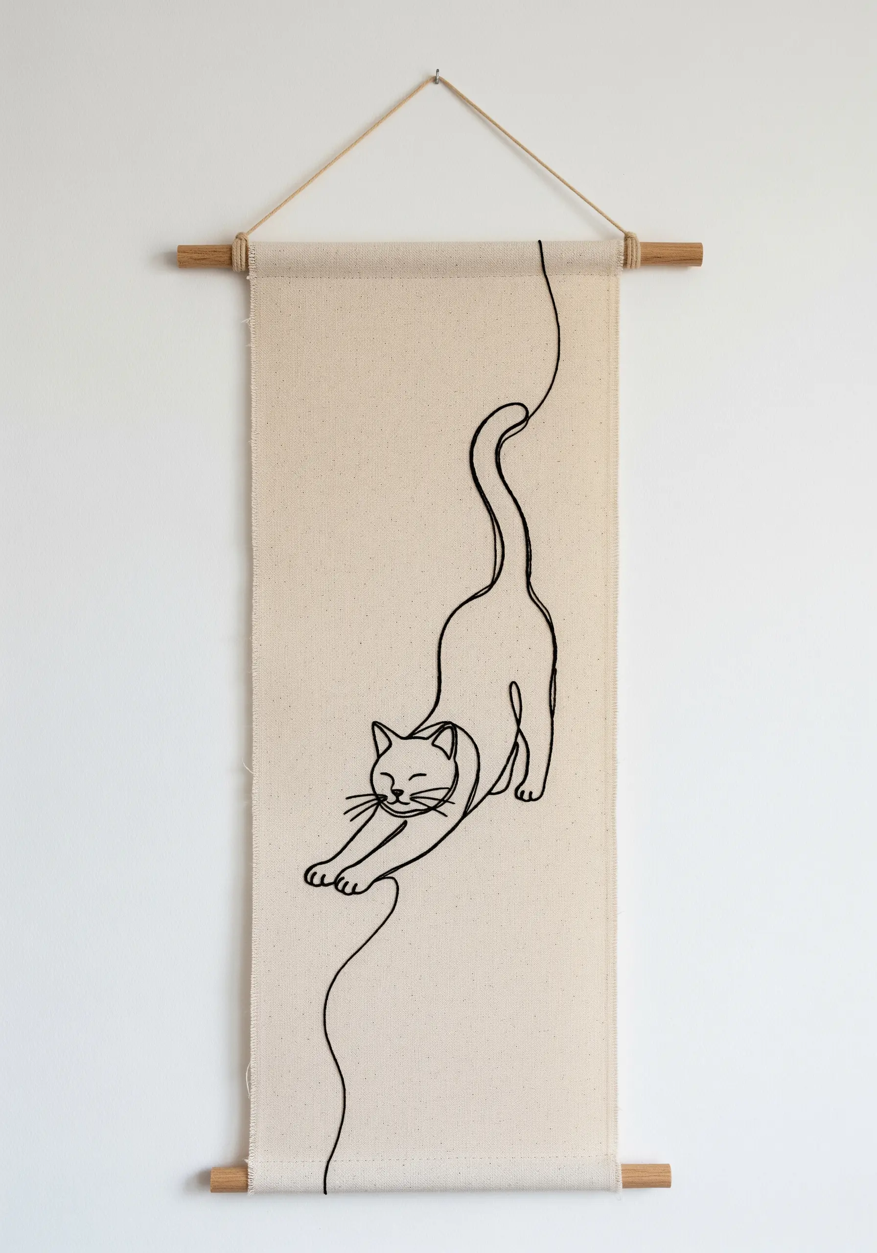 A single-line embroidery of a stretching cat on a long, hanging fabric banner.