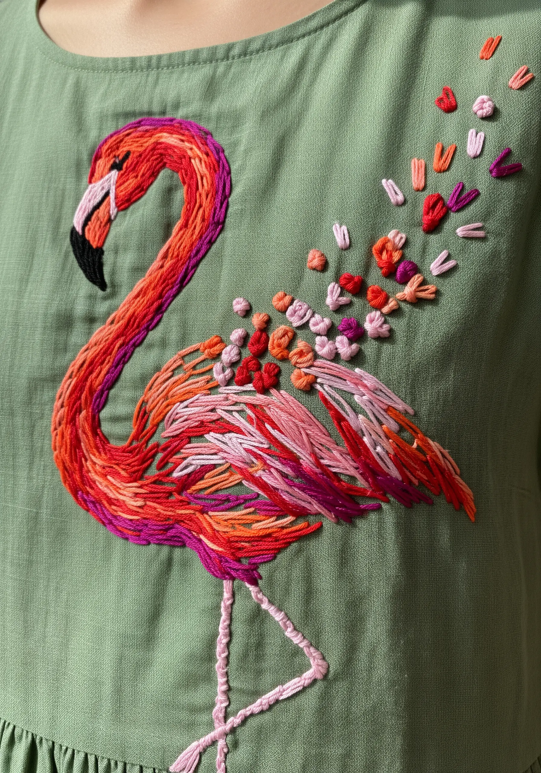 Abstract flamingo embroidered with variegated thread and scattered French knots.
