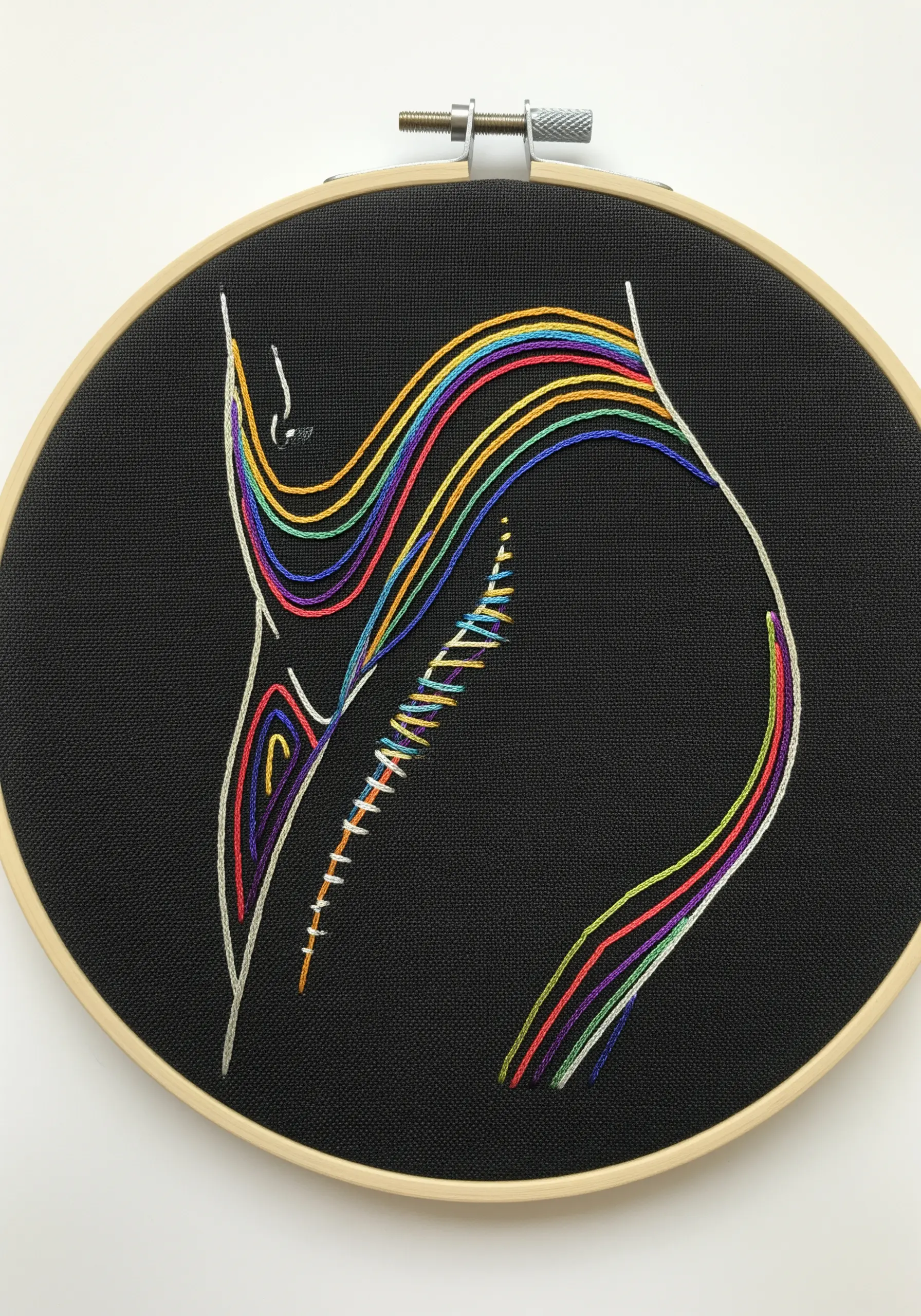 Abstract silhouette of a body filled with flowing rainbow-colored satin stitches on black fabric.