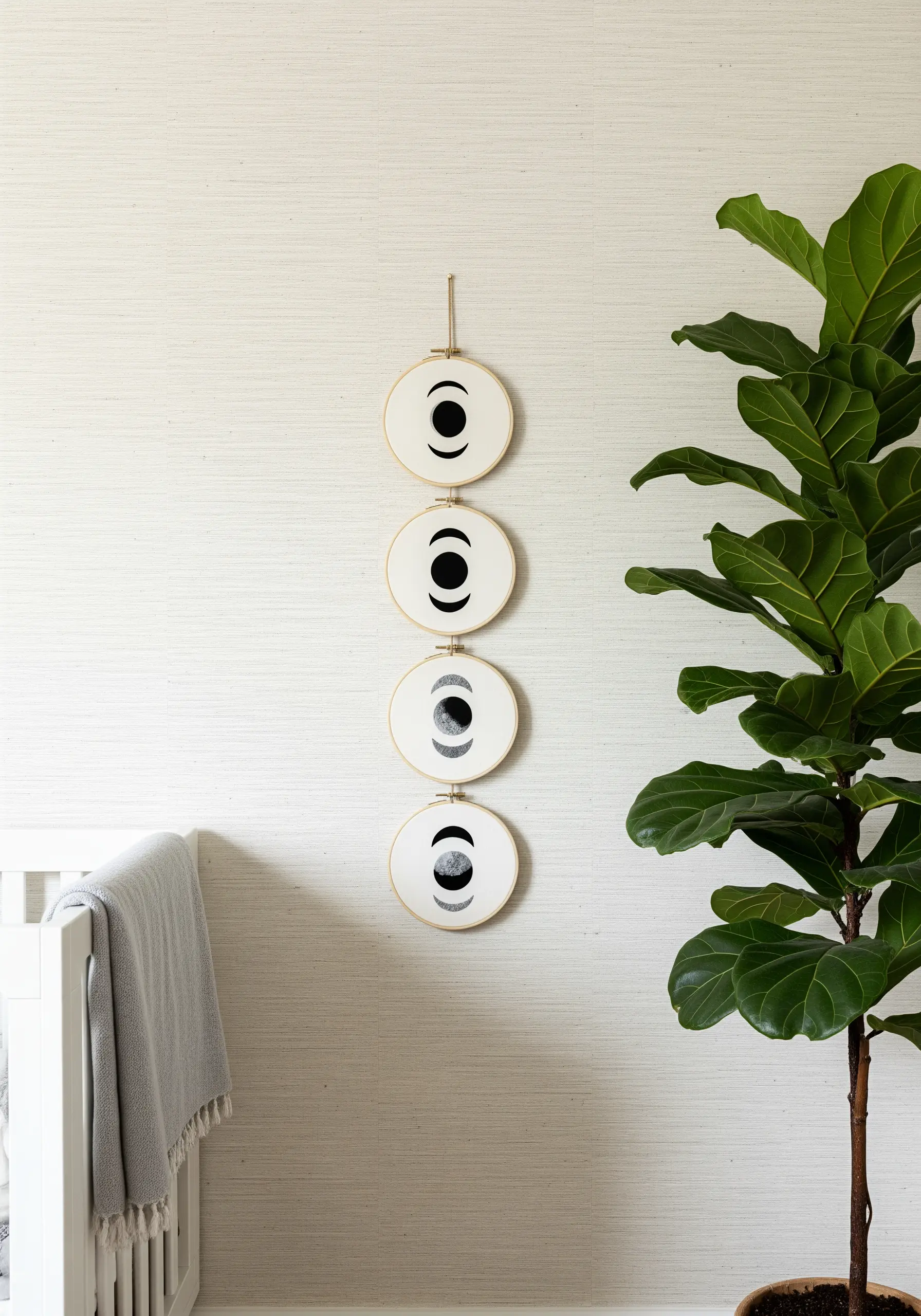 A vertical stack of four hoops showing moon phases using negative space.
