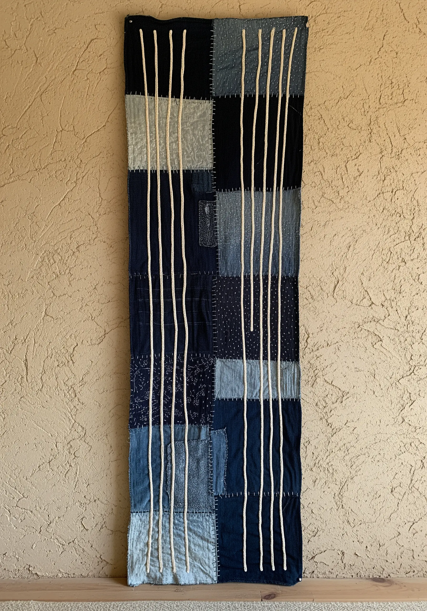 A Japanese Boro and Sashiko inspired wall hanging made of patched indigo fabrics.