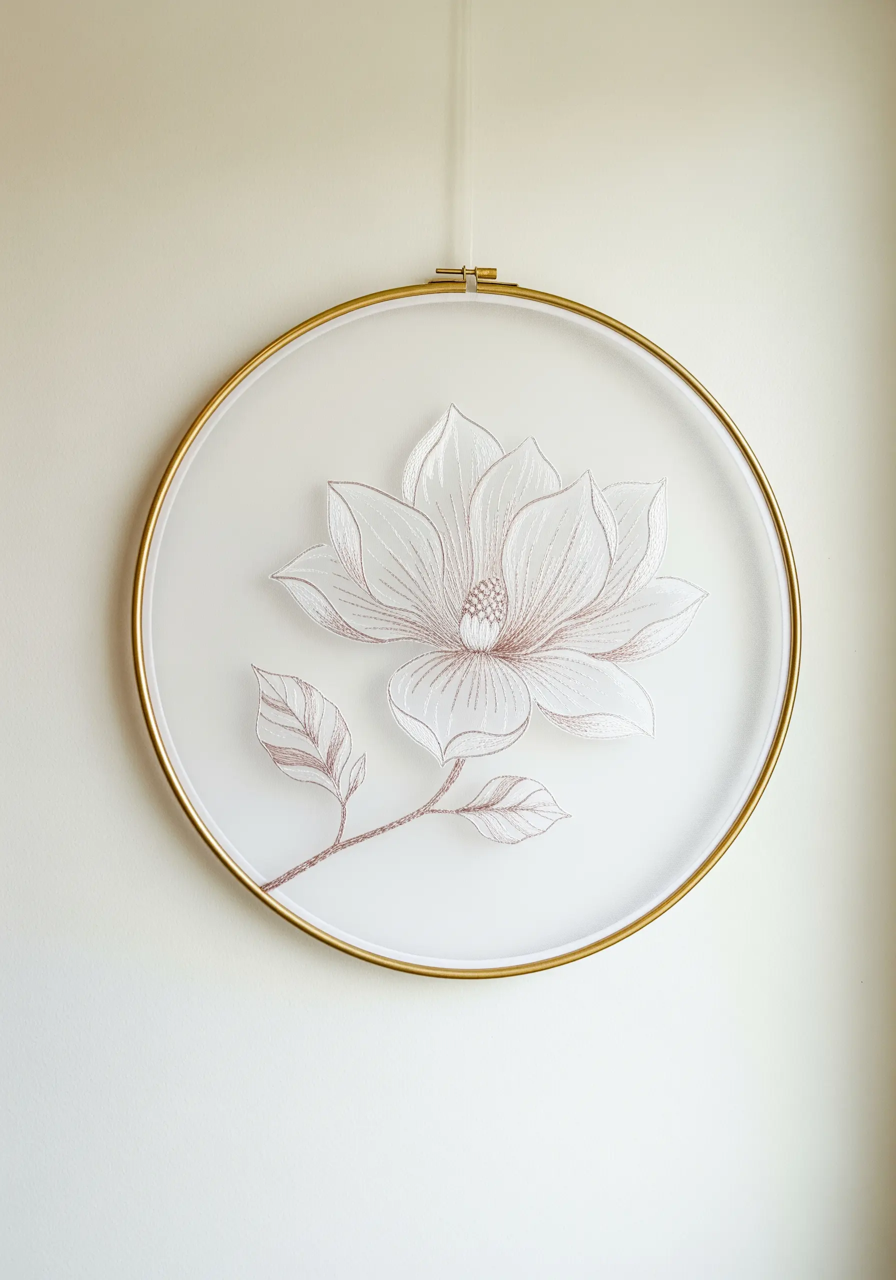 A delicate magnolia flower embroidered on sheer organza in a modern gold hoop.
