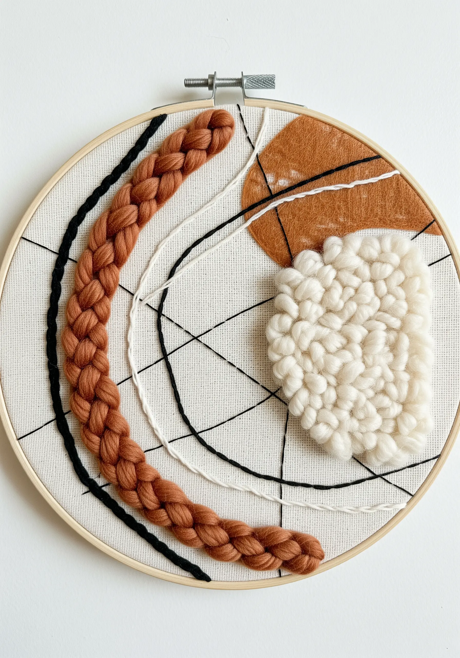 Abstract hoop art combining a thick yarn braid, woven yarn, and felt appliqué.
