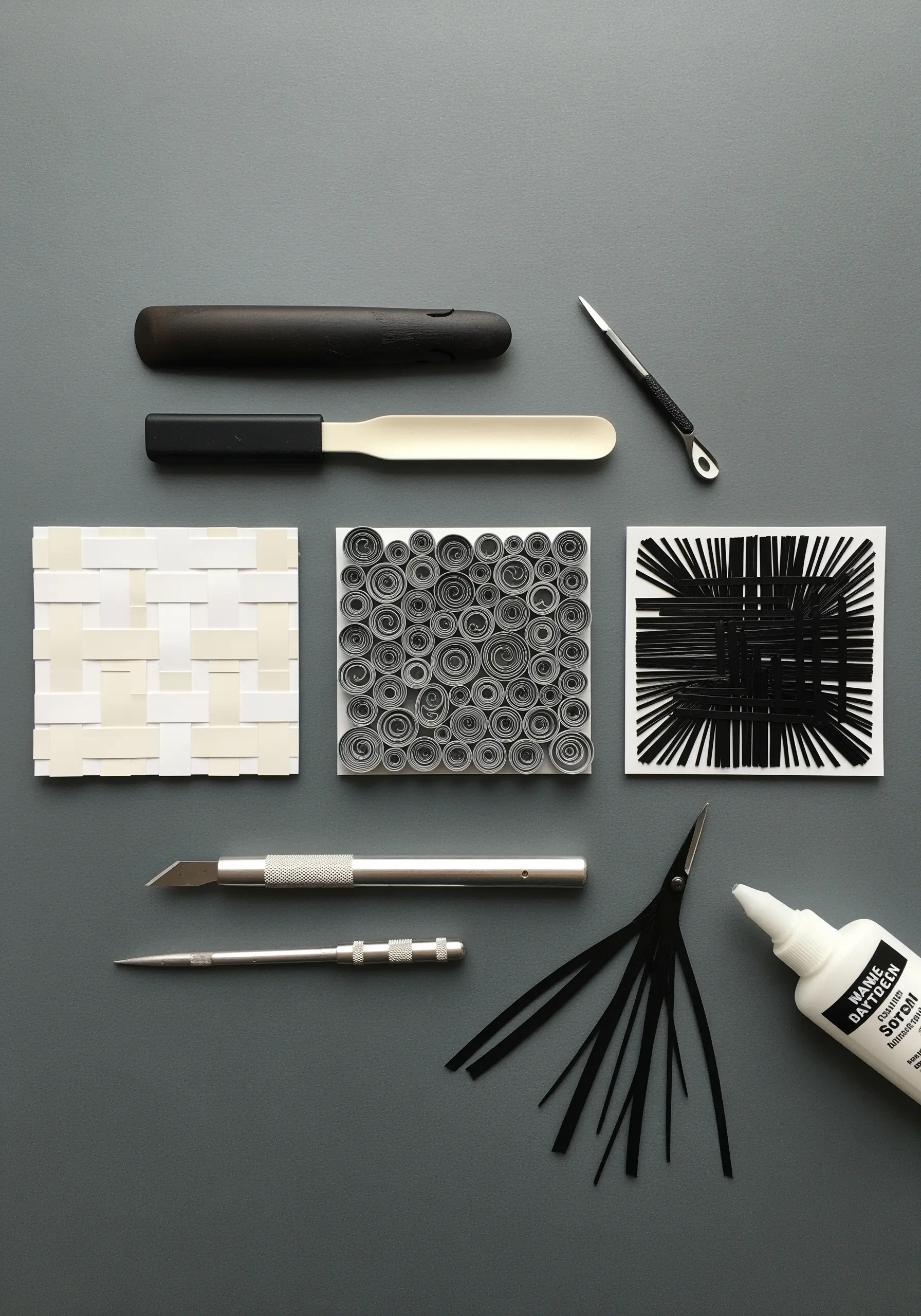 A monochrome display of paper art techniques, including weaving, coiling, and fringing.