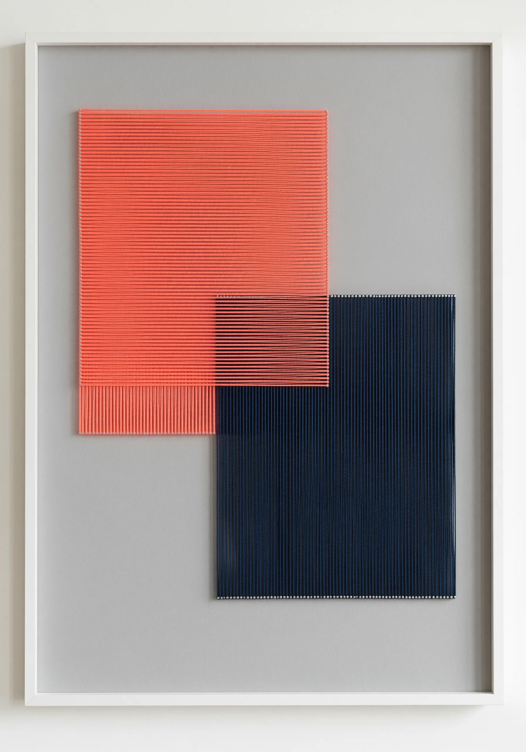 Abstract wall art with two overlapping blocks of dense vertical stitches in coral and navy blue.