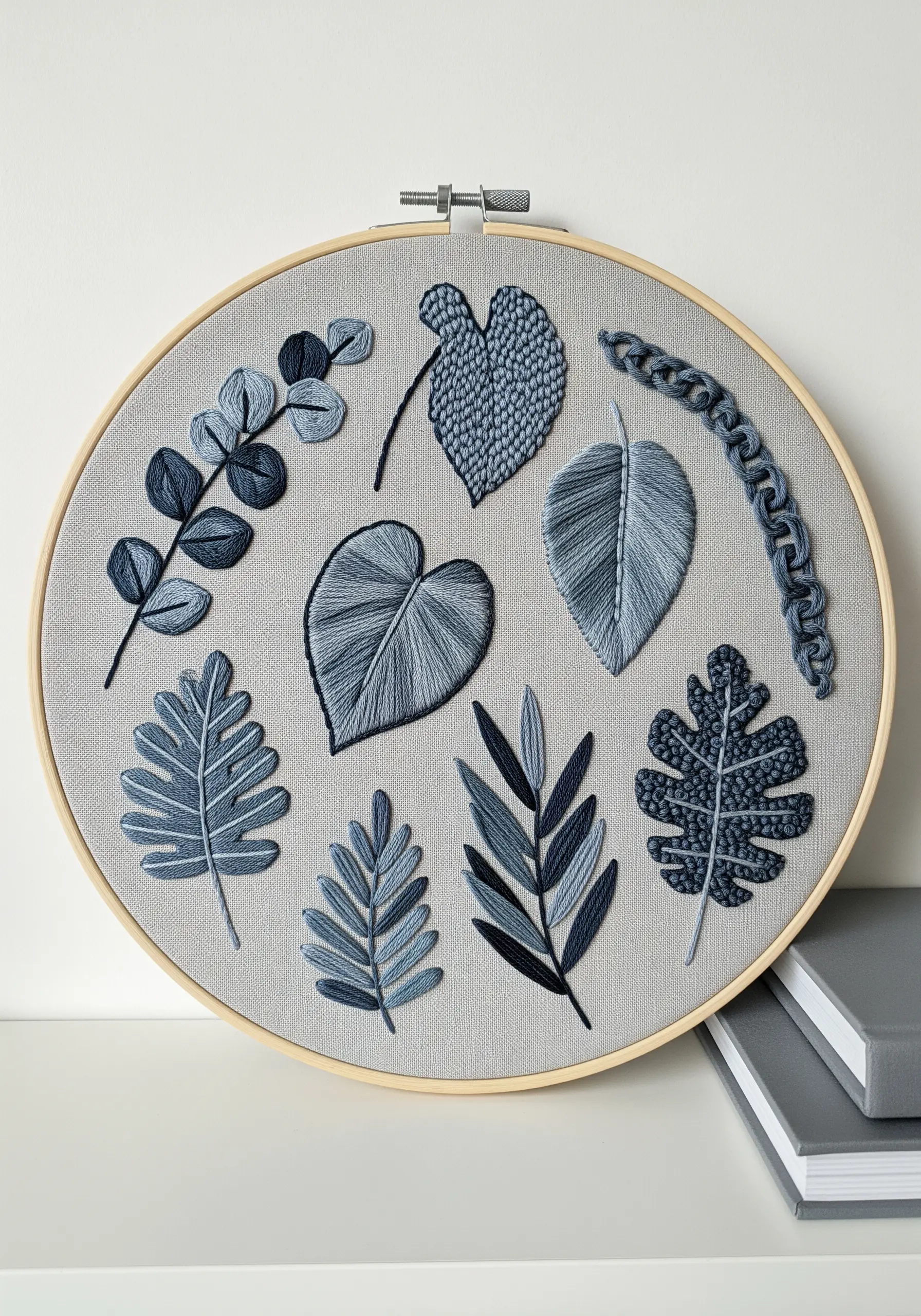 A sampler of various leaf shapes embroidered in shades of dusty blue, showcasing different textures.