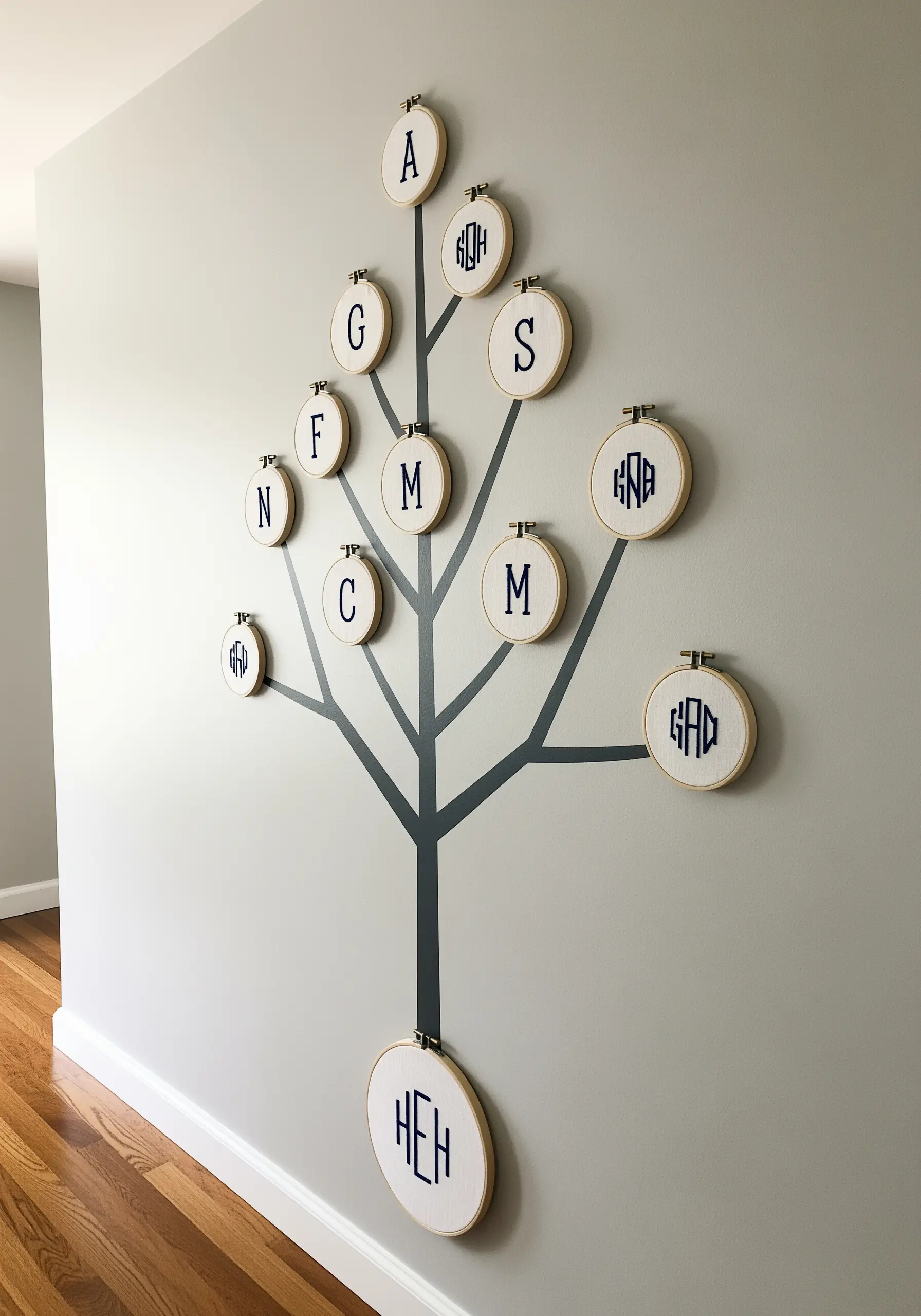 Monogram embroidery hoops arranged as a family tree on wall