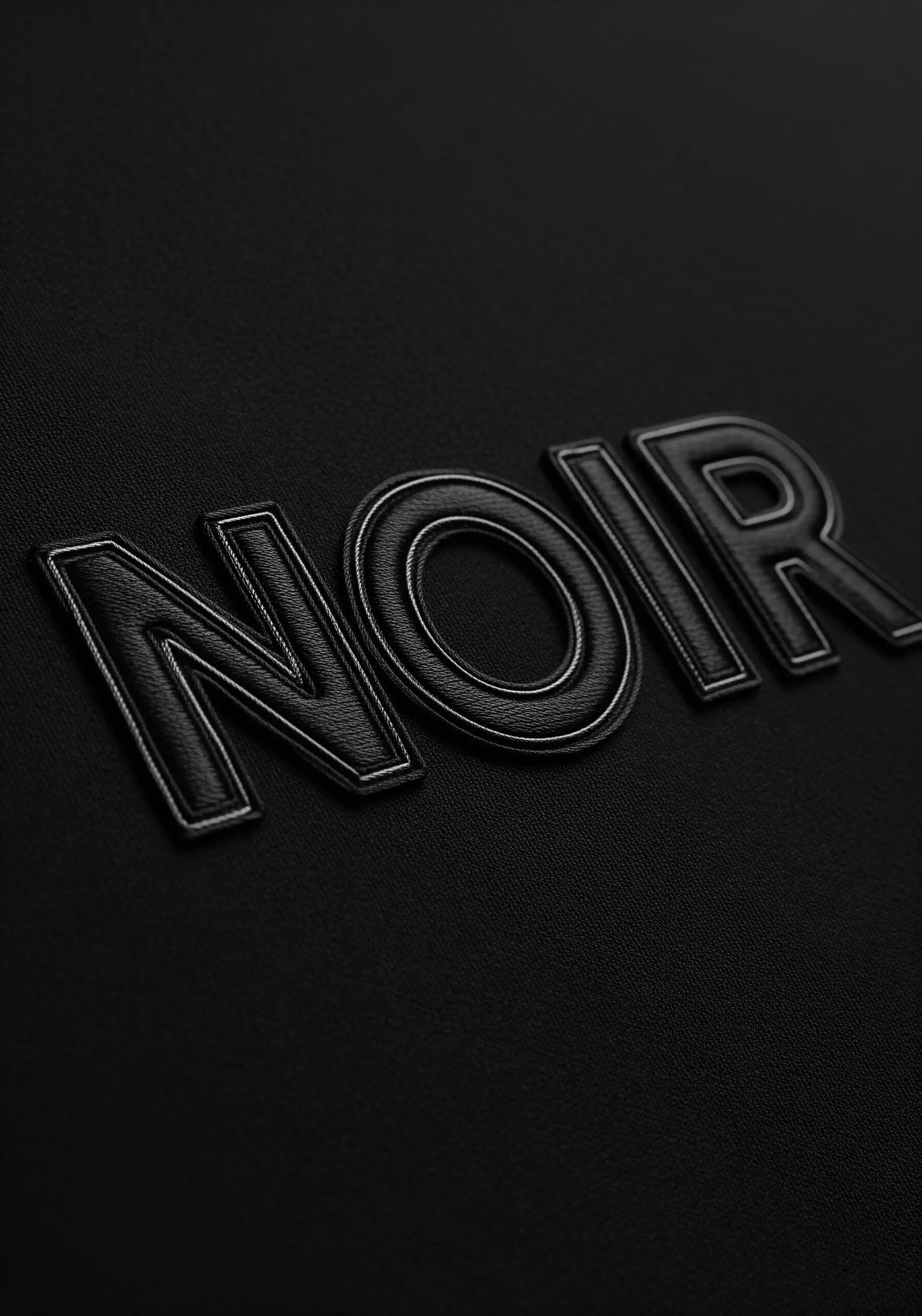 Black on black embossed style typography spelling NOIR