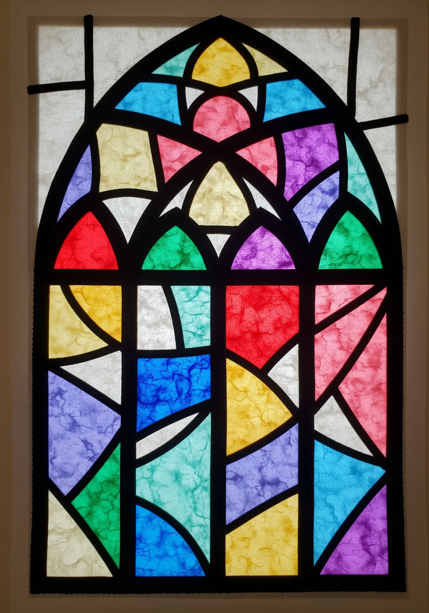 A stained-glass window effect created with colored paper outlined with thick black thread.