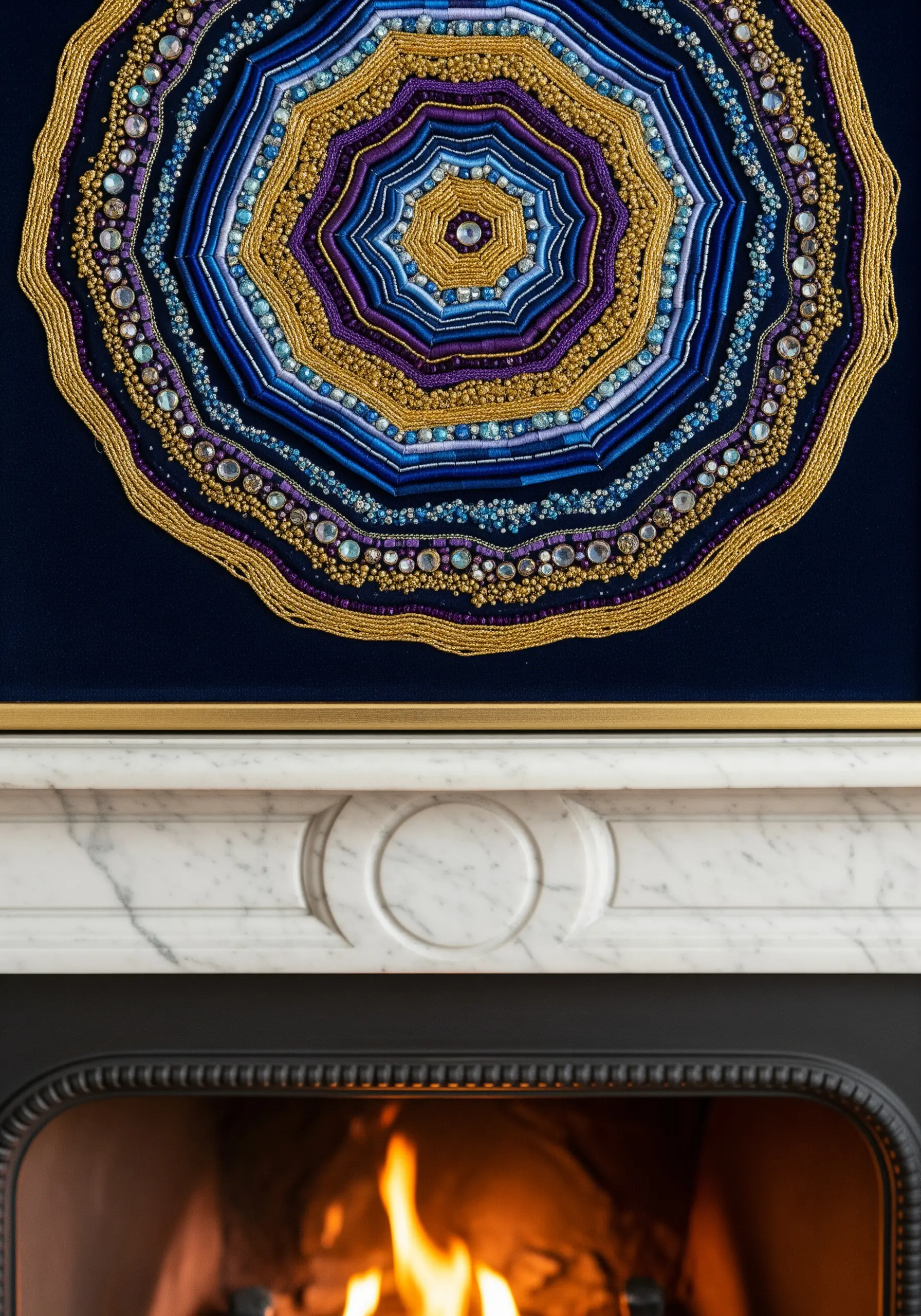 A detailed, concentric mandala made with gold, blue, and purple beads and threads.