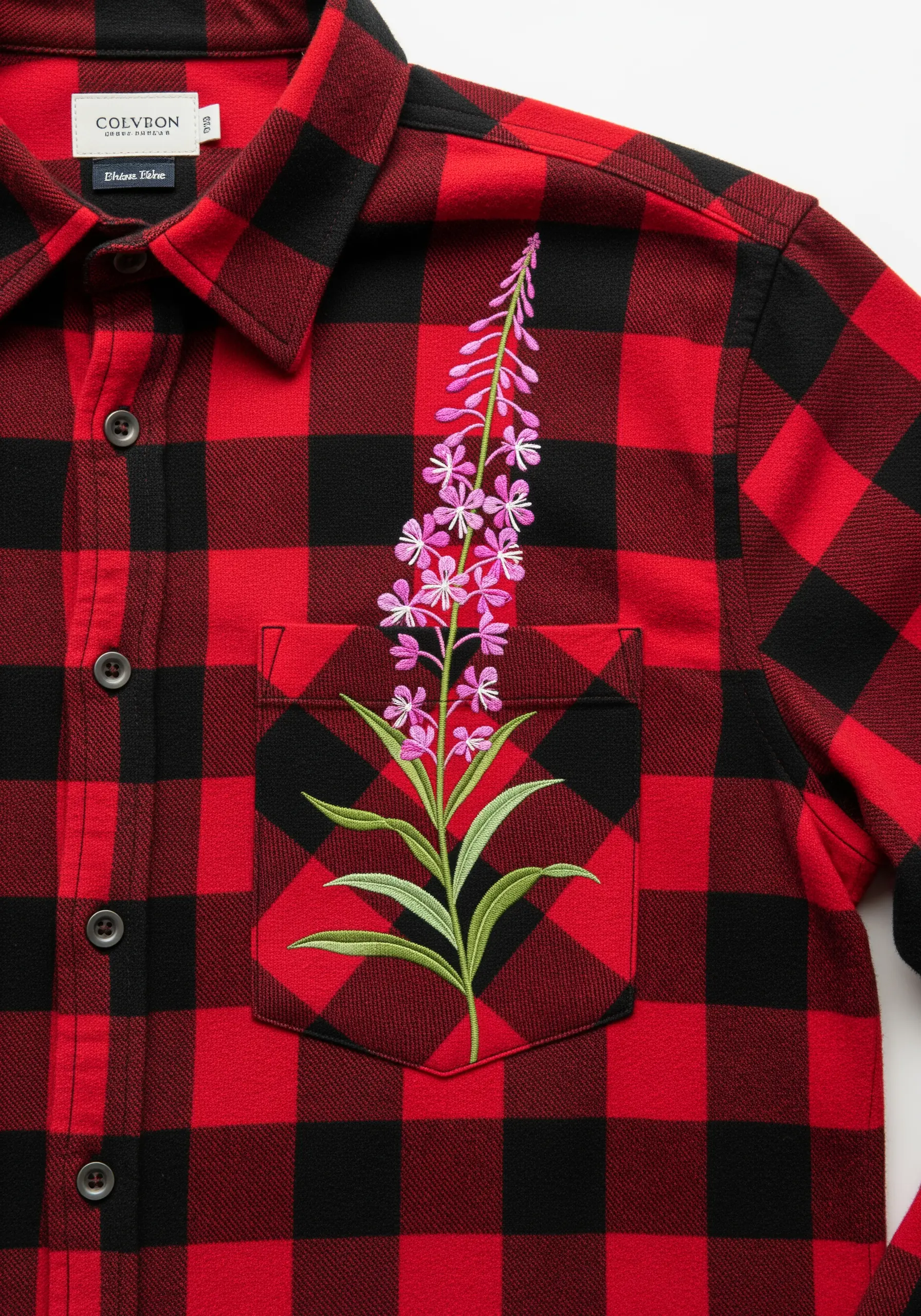 A tall pink fireweed flower embroidered on the pocket of a red and black buffalo plaid shirt.