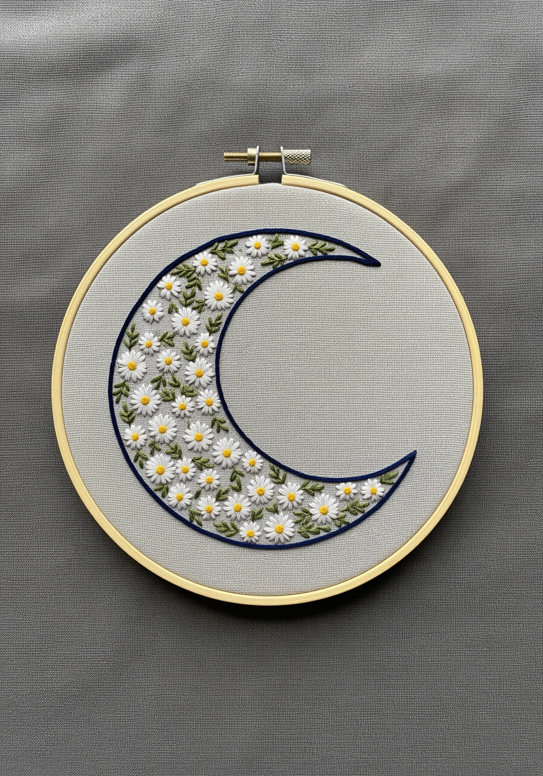 Crescent moon shape filled with embroidered white daisies and greenery