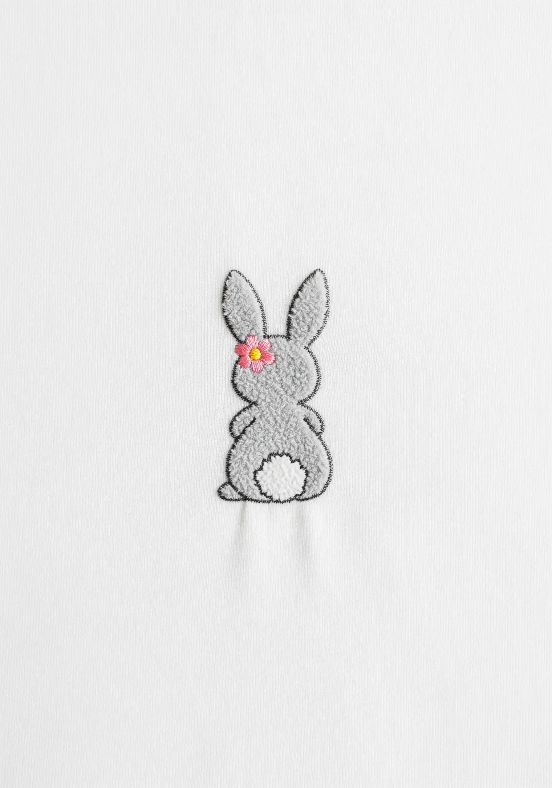 Grey bunny embroidery viewed from behind with a textured fluffy tail