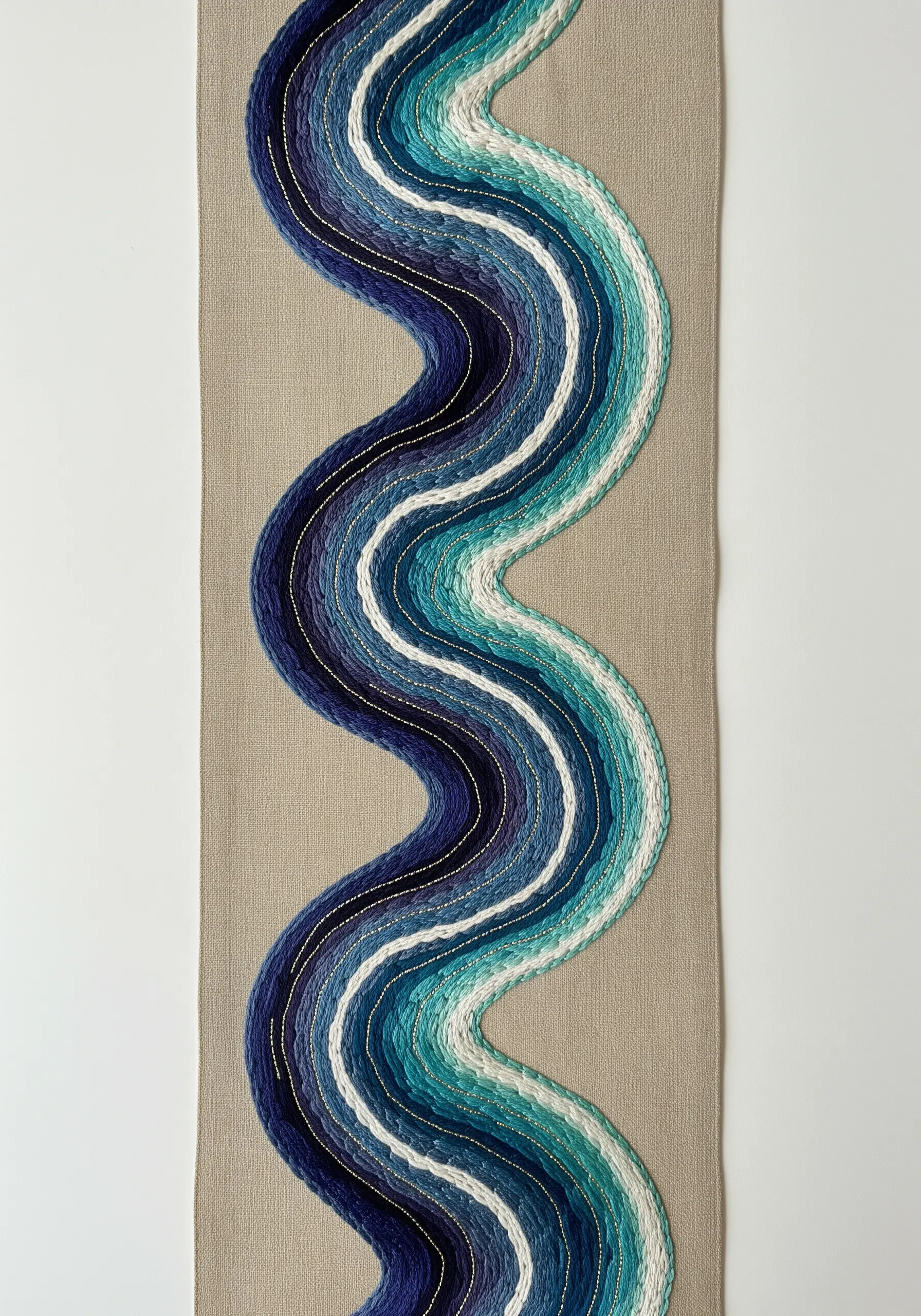 An abstract river design with couched blue threads and delicate gold accents.