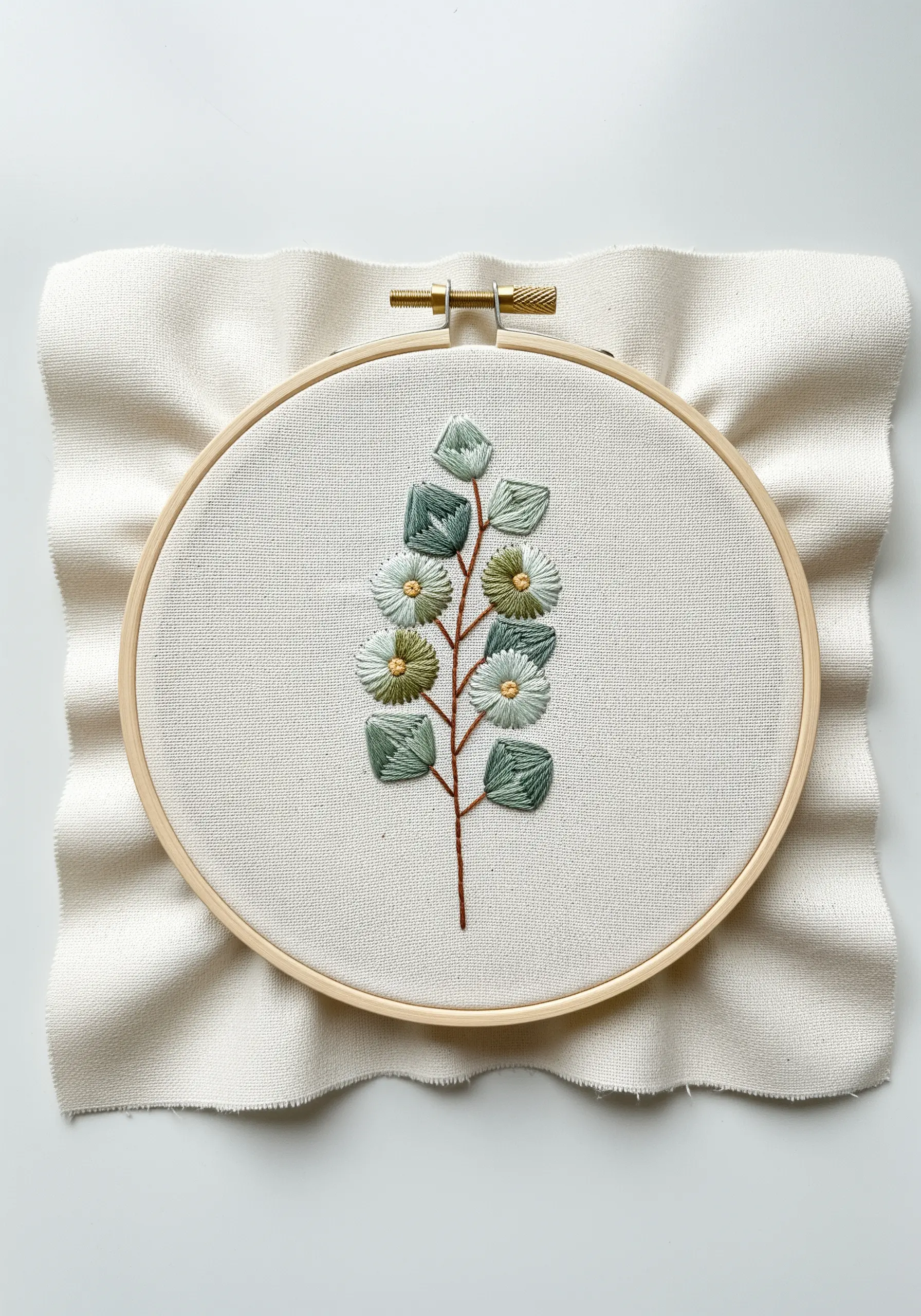 A botanical branch with dimensional, woven leaves and flowers in shades of green and white.