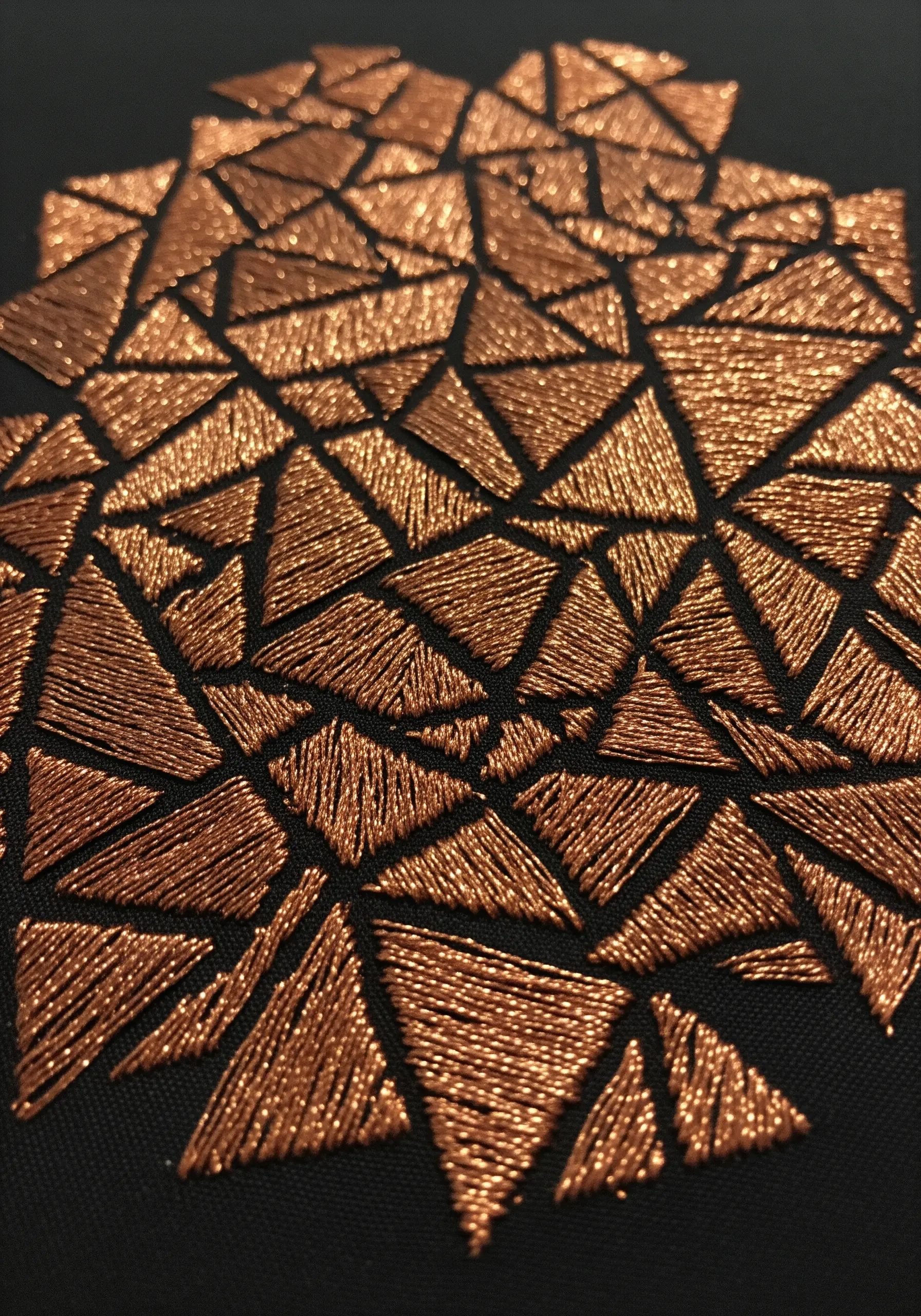 Copper thread geometric embroidery with varying stitch directions