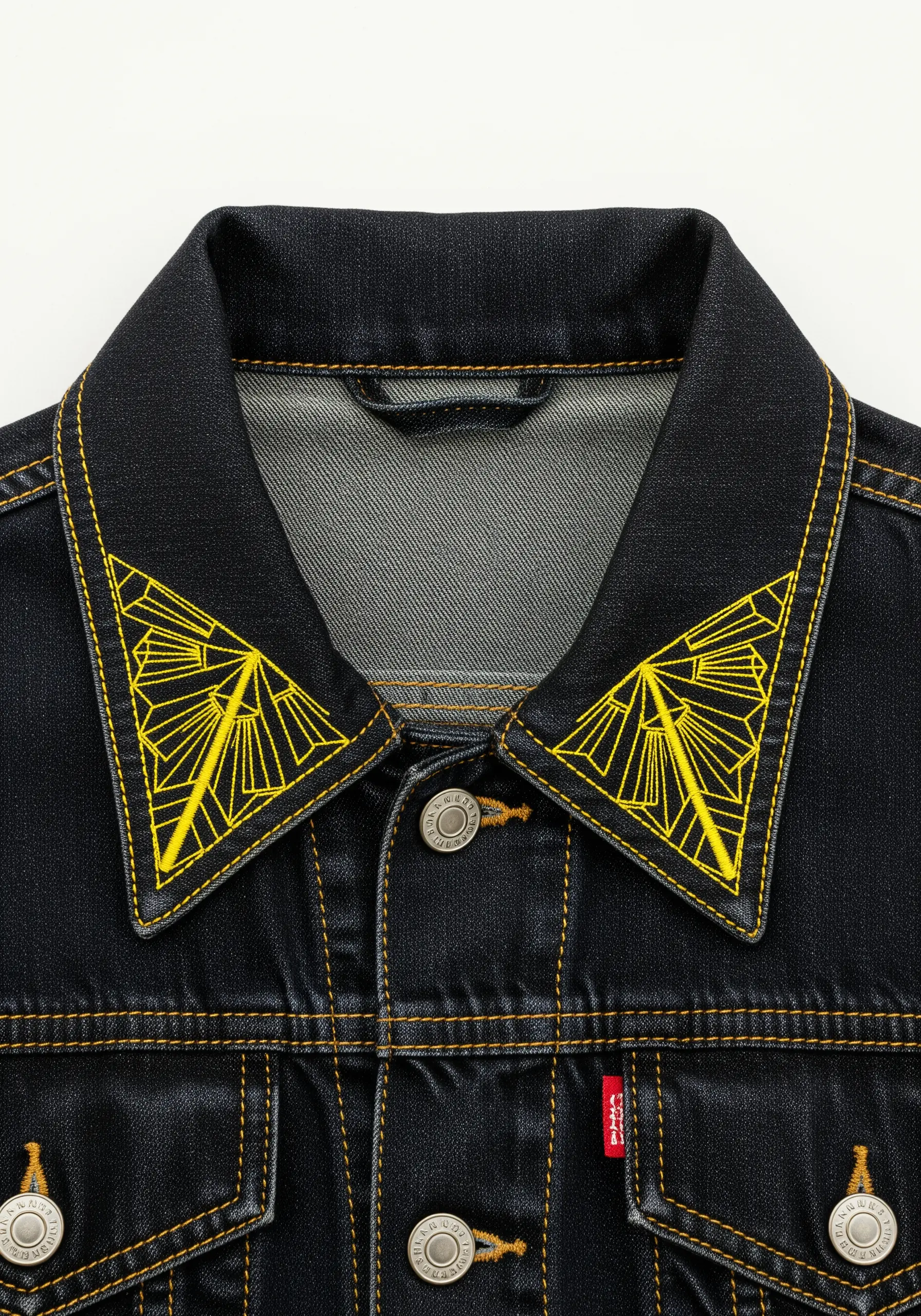 Geometric Art Deco fan designs in neon yellow embroidered on a denim jacket collar.