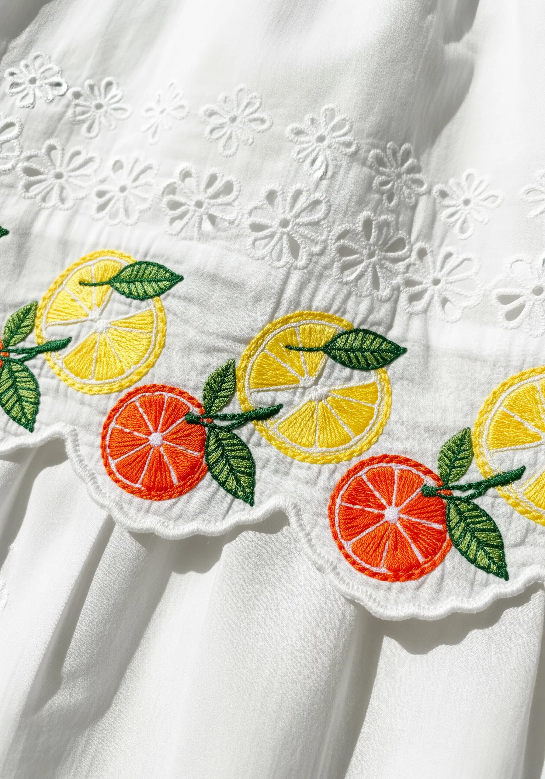 White eyelet fabric with embroidered lemon and orange slices