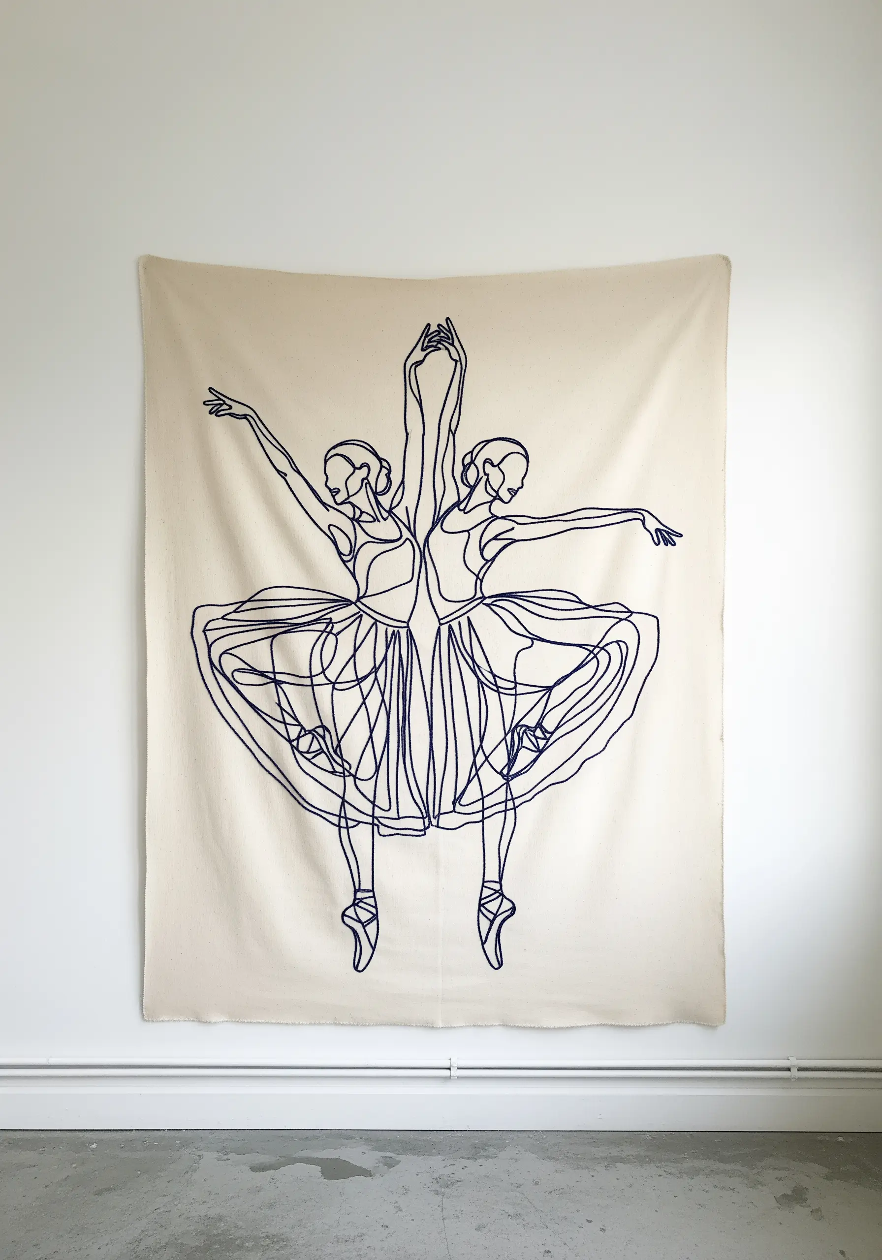 Large-scale line art embroidery of dancers on a wall tapestry.