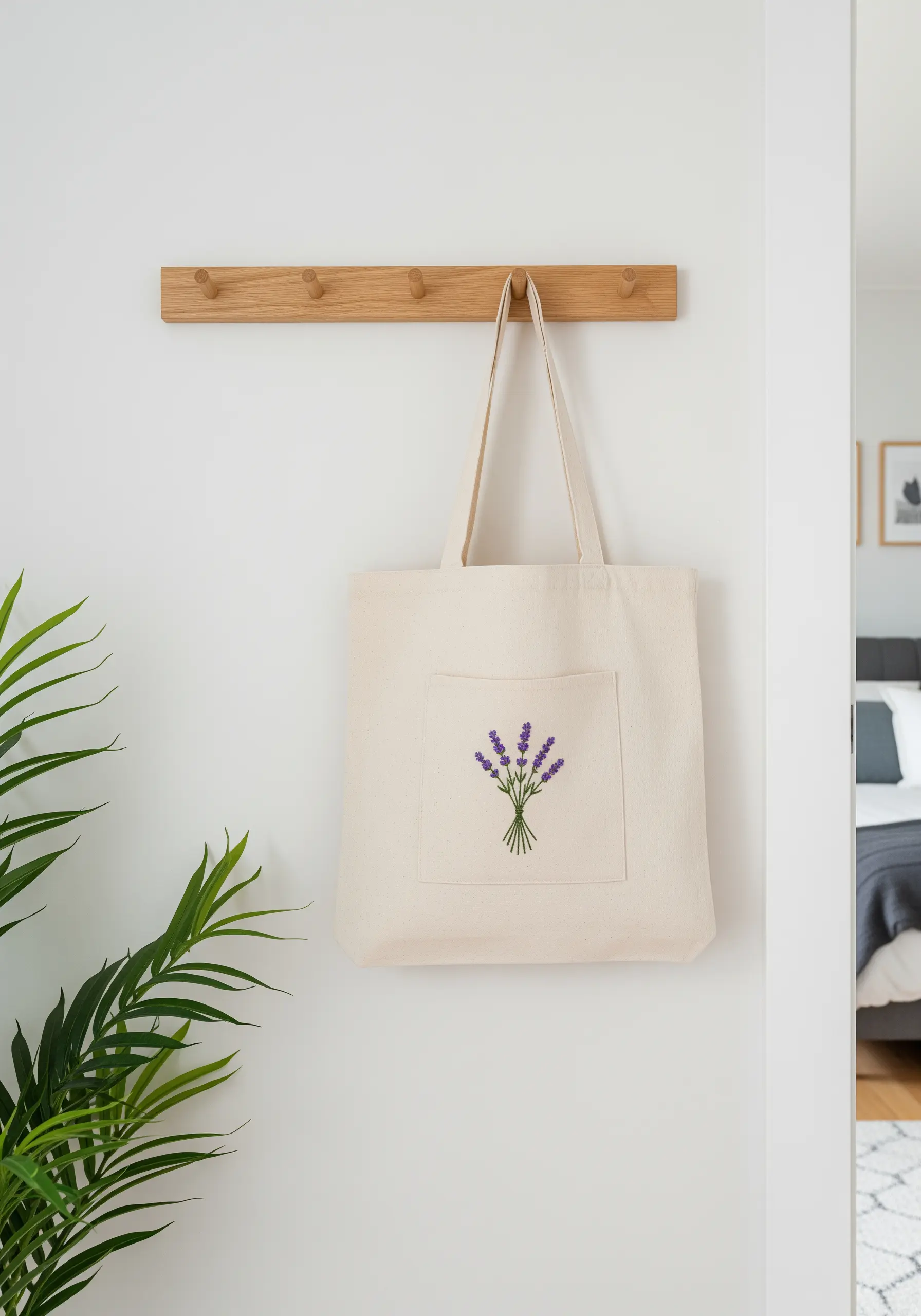 Canvas tote bag hanging on a rack featuring a simple embroidered lavender bouquet