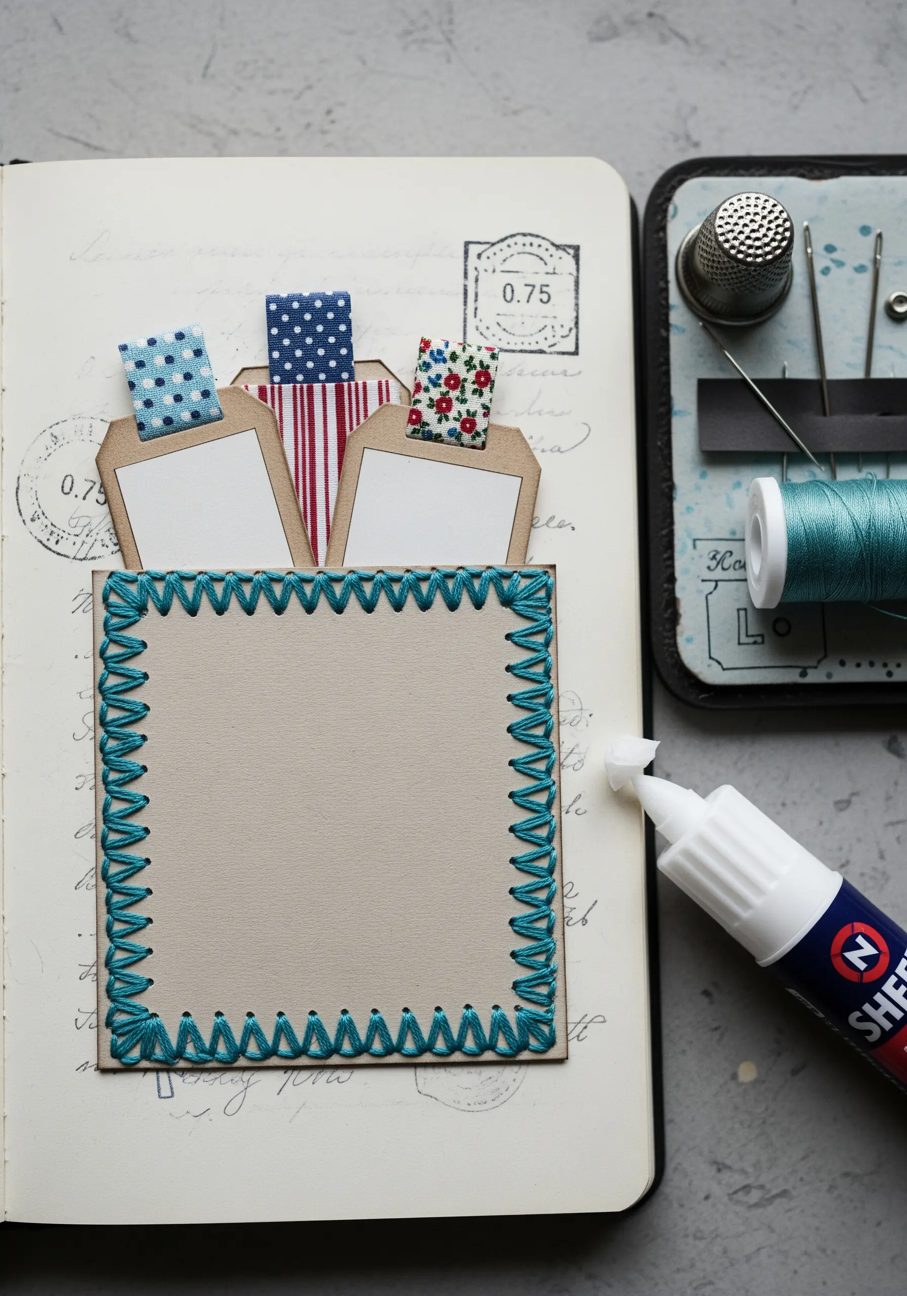 Sketchbook page with a stitched paper pocket holding tags