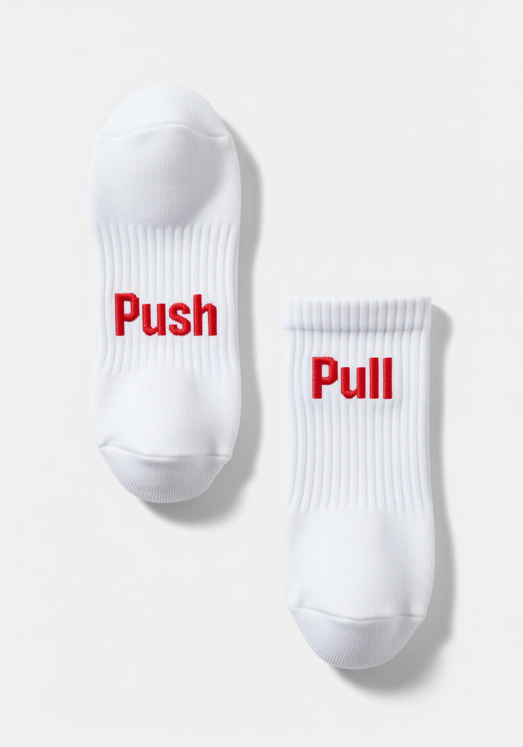 Red embroidered words “Push” and “Pull” on the top of white athletic socks.